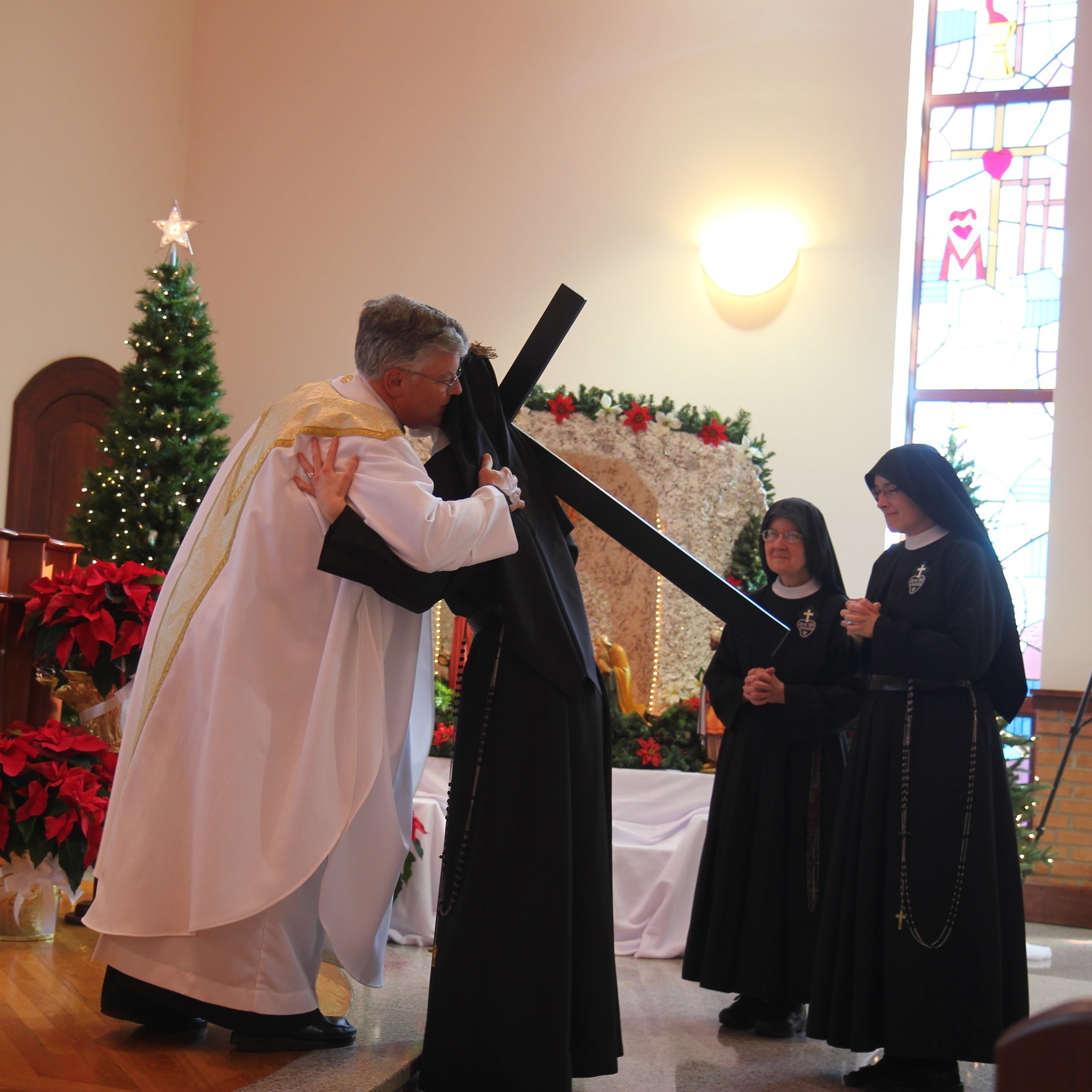  Sister exchanges the Sign of Peace with the Celebrants (con-celebrant Fr. John Shork, CP is pictured), her family, and her Passionist sisters 