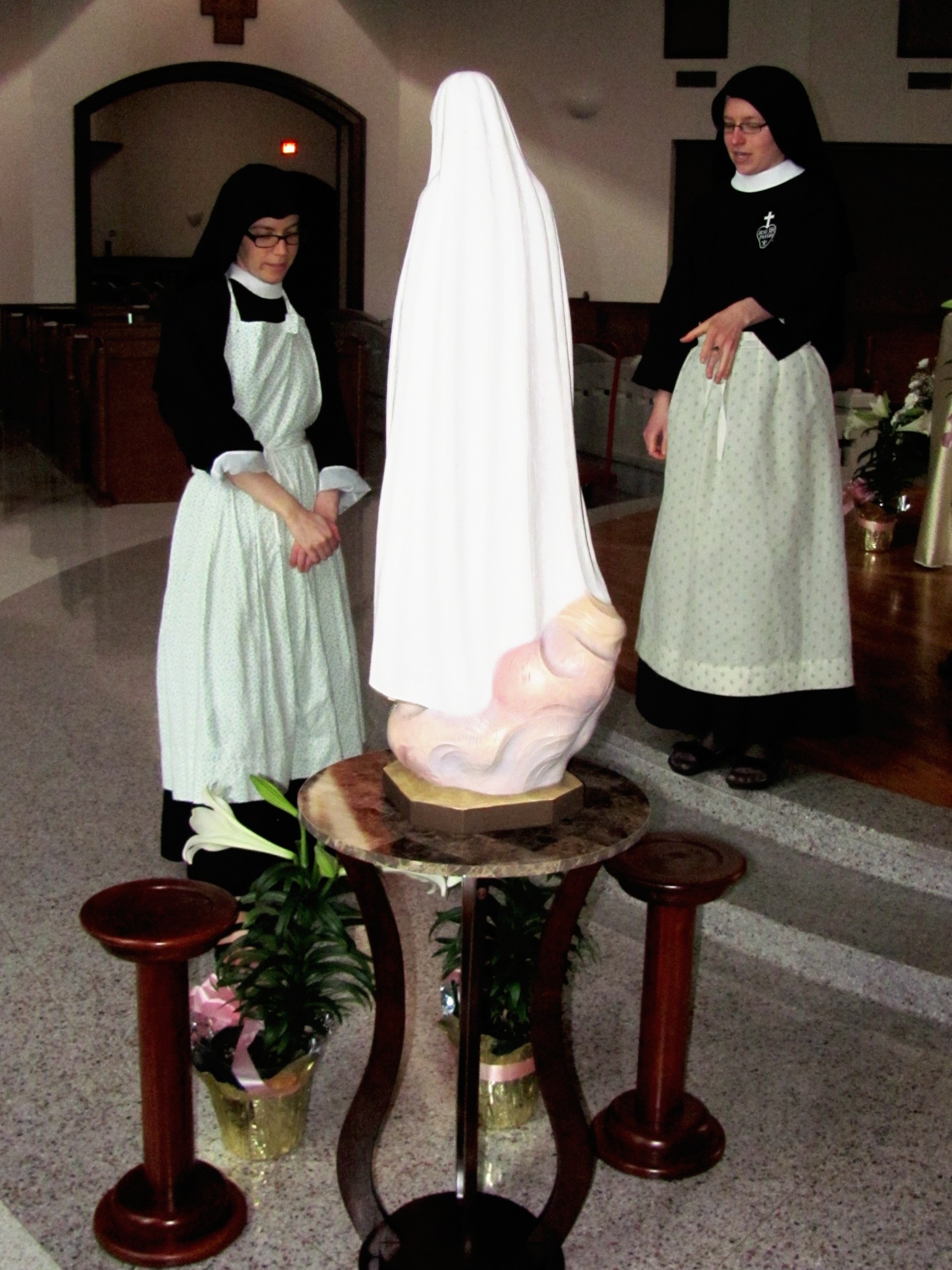  Are they contemplating the flower arrangement or Our Lady? 