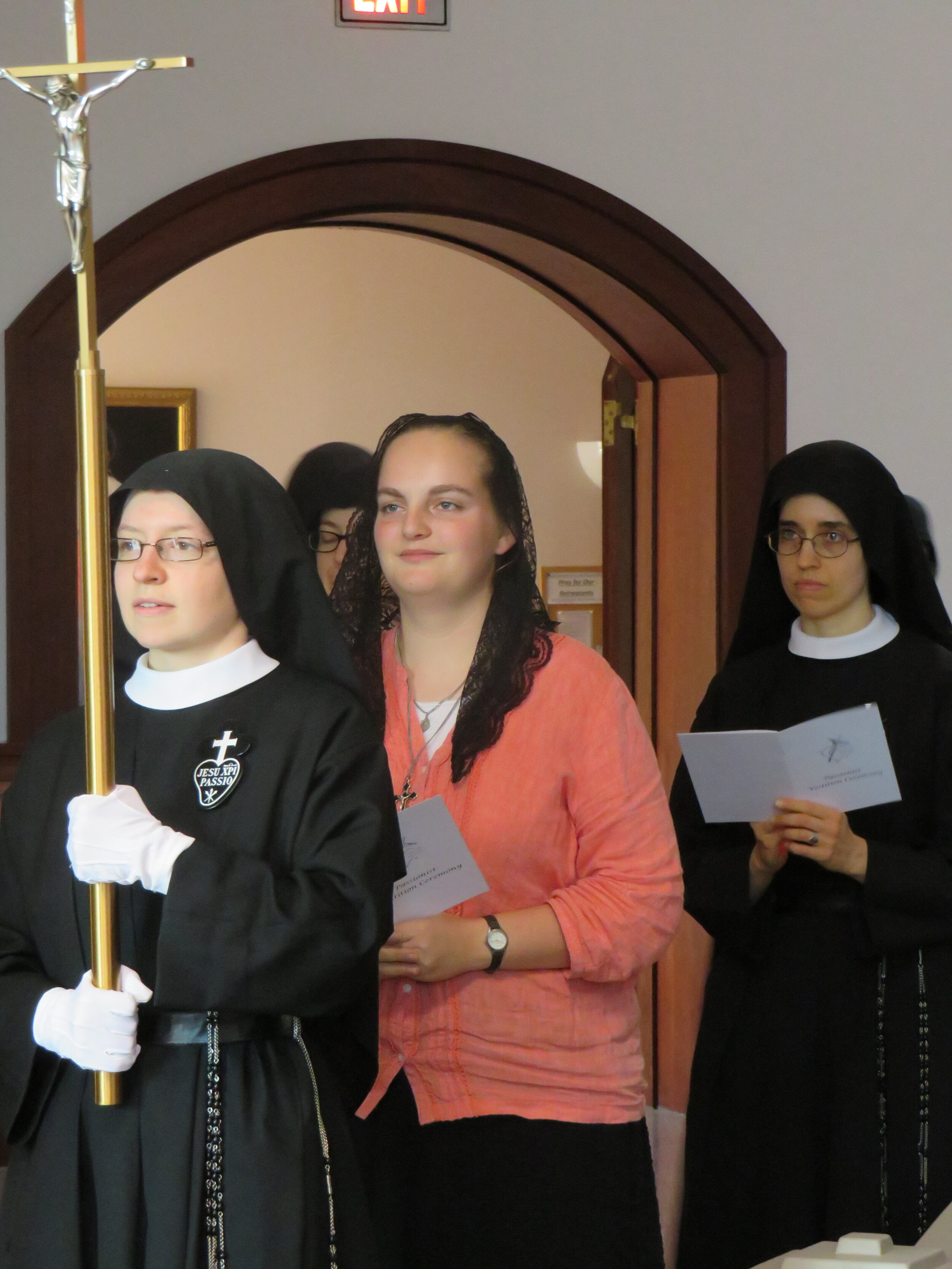  The entrance procession; each of the professed nuns carries a votive light to be place around the image of Our Holy Founder, St. Paul of the Cross.  Pictured here are Sr. Frances Marie, aspirant Abbey, and Sr. Mary Andrea. 