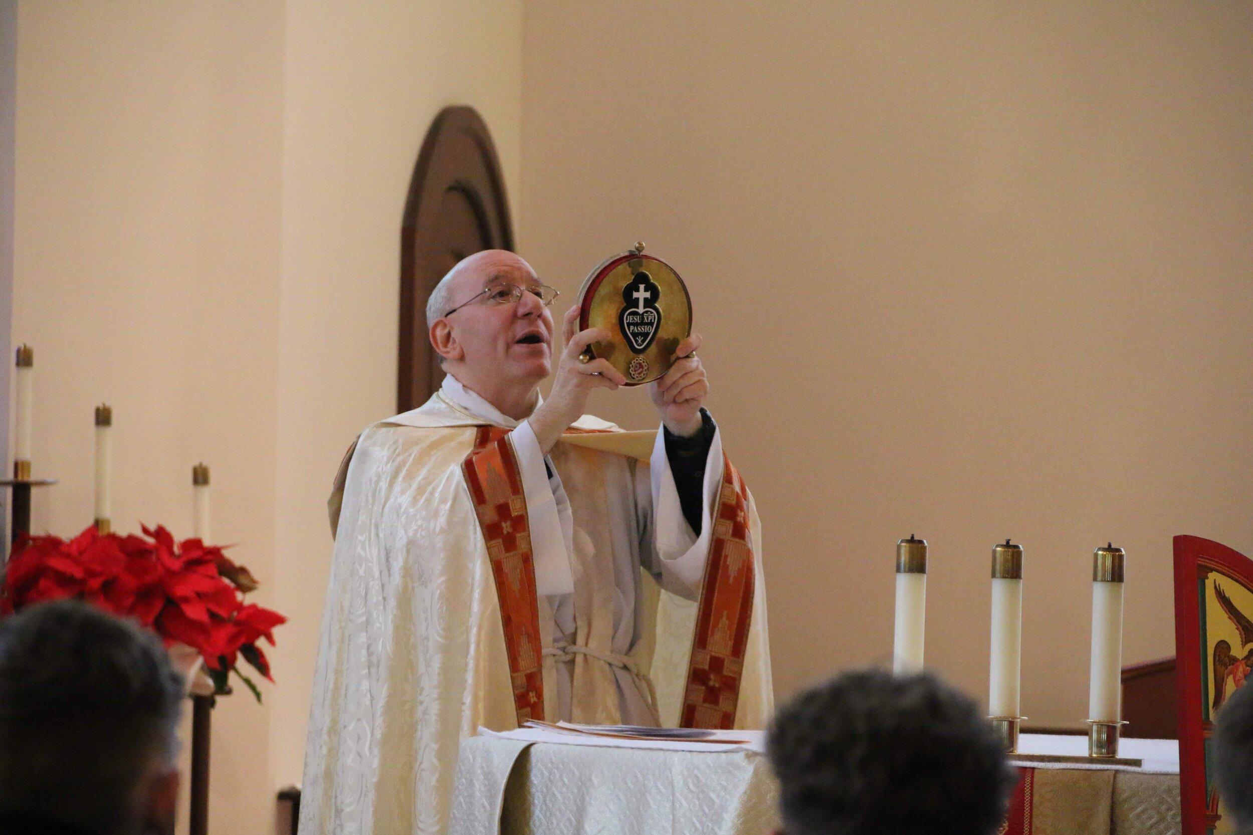  Fr. Lou Caporiccio, CPM, blesses the congregation with the relic of St. Paul of the Cross.   Photo courtesy of Elizabeth Wong Barnstead/WKC  