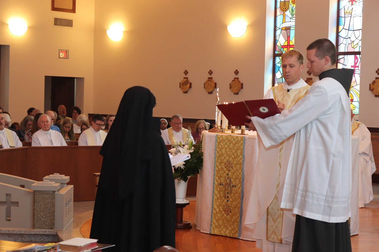  The examination: Fr. Tony  formally questions Sister on her resolve to profess and live the five Passionist vows perpetually. 