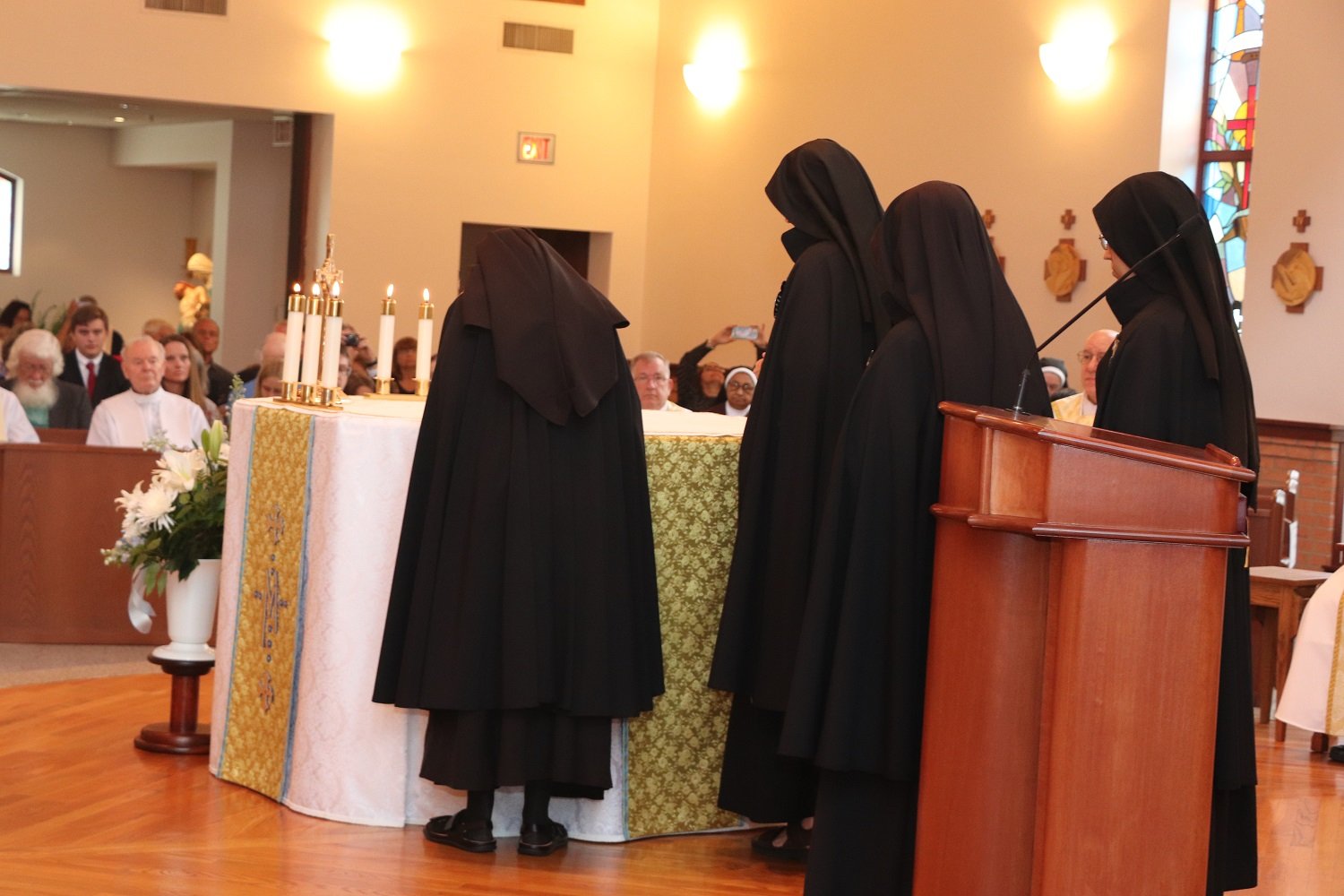  Signing the vow formula on the altar; this paper remains on the altar throughout the Mass, symbolizing the union of Sister’s self-offering with that of Christ 