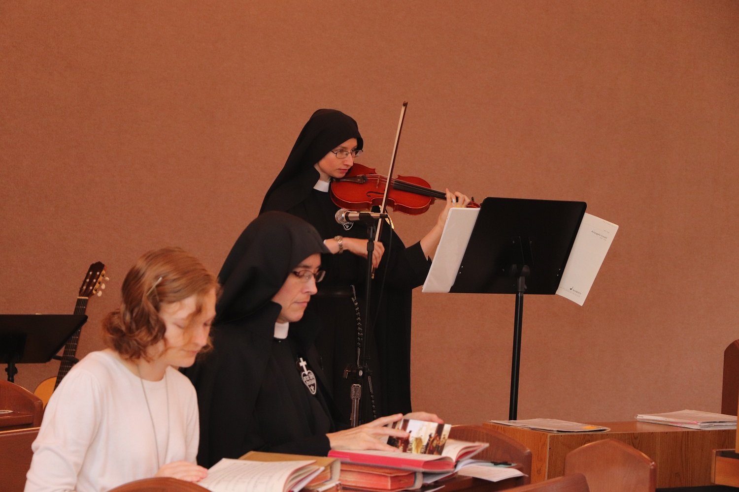  Sr. Cecilia Maria (on violin) and Sr. Maria Faustina (on organ) played an instrumental version of “In Perfect Charity” after Holy Communion.  In the foreground, Mother John Mary kneels next to our new Aspirant, Emma! 