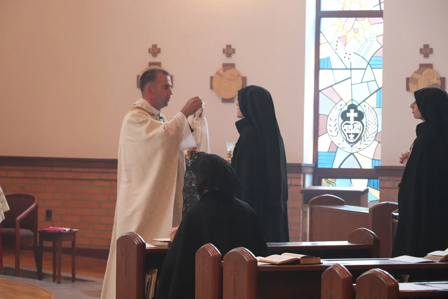 Mother receives her Sacramental Spouse from the hands of her priest-brother