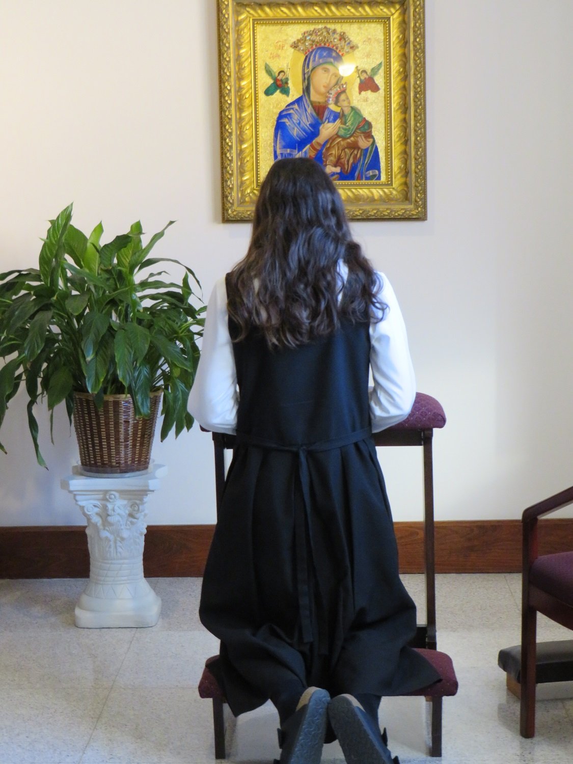  The novice-to-be, kneeling in prayer before the Vestition ceremony begins 