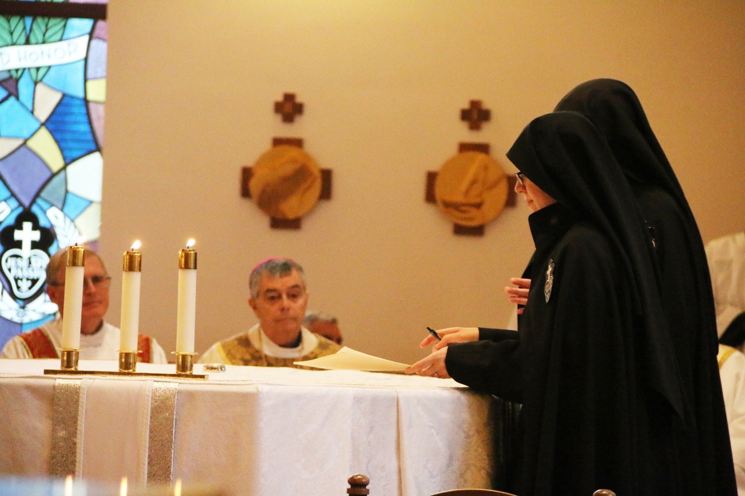  Sister signs her vow formula on the altar, where it remained throughout the rest of Mass.   (Photo: Elizabeth Wong Barnstead, Western KY Catholic)  