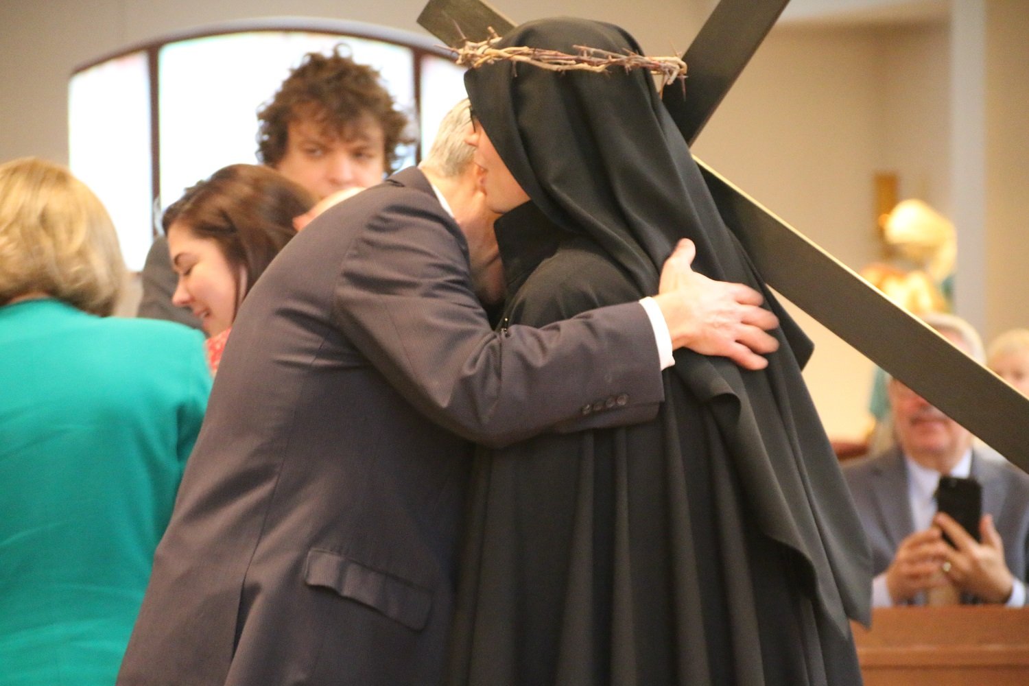  Exchanging the sign of peace with her father, Paul.   (Photo: Elizabeth Wong Barnstead, Western KY Catholic)  