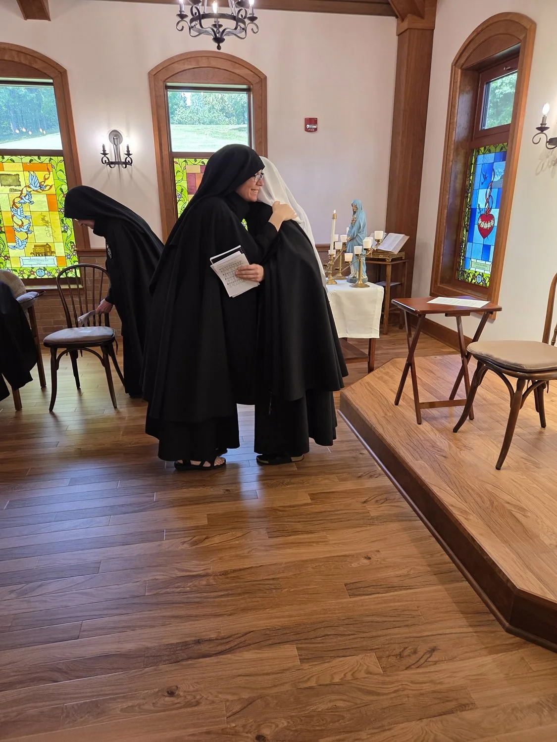  At the conclusion of the ceremony, the newly-vested novice exchanges the Sign of Peace (aka “liturgical hug”!) with each of her Sisters in community. 