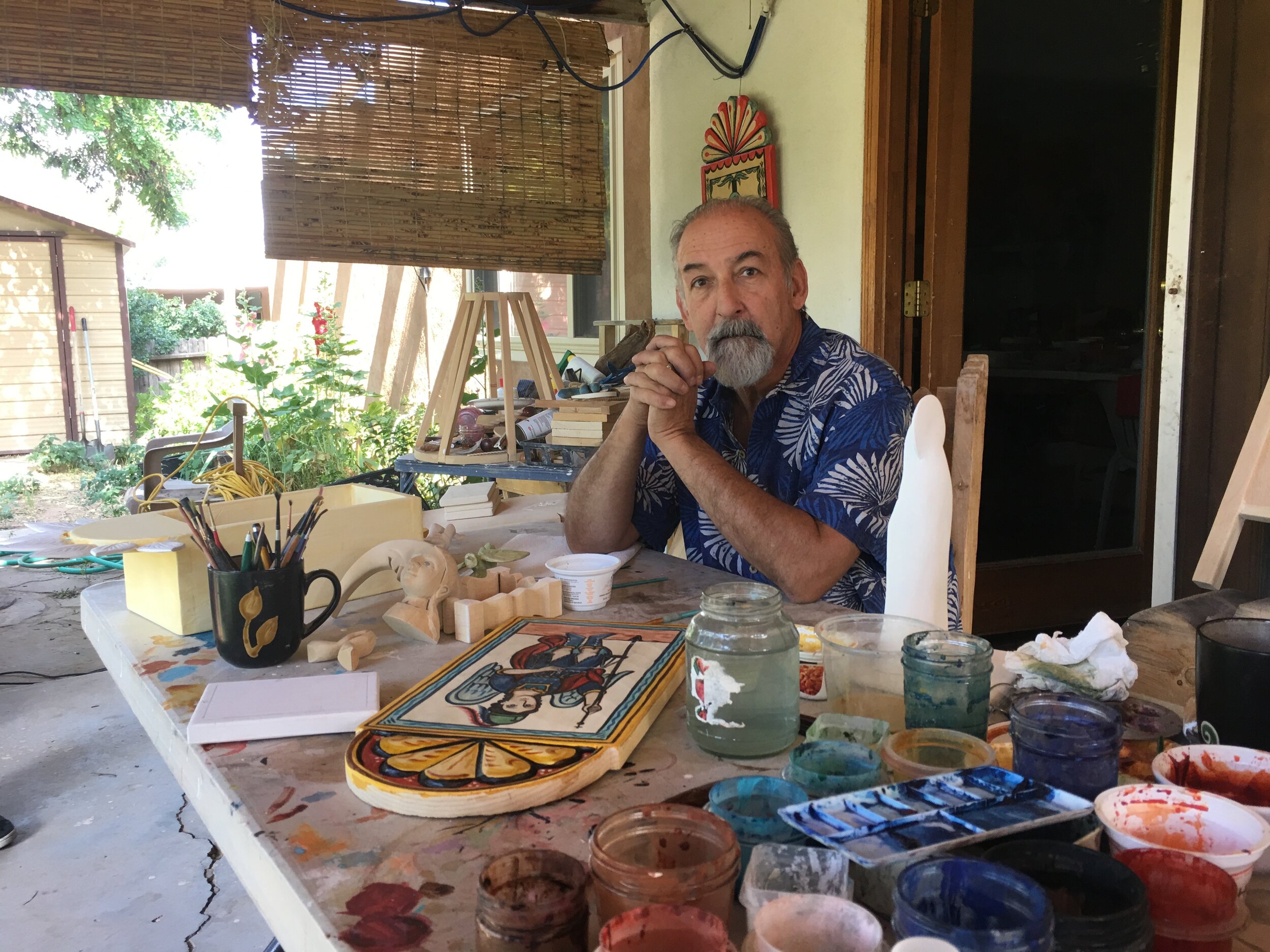 Artist Charlie Carrillo working outdoors on his retablos.