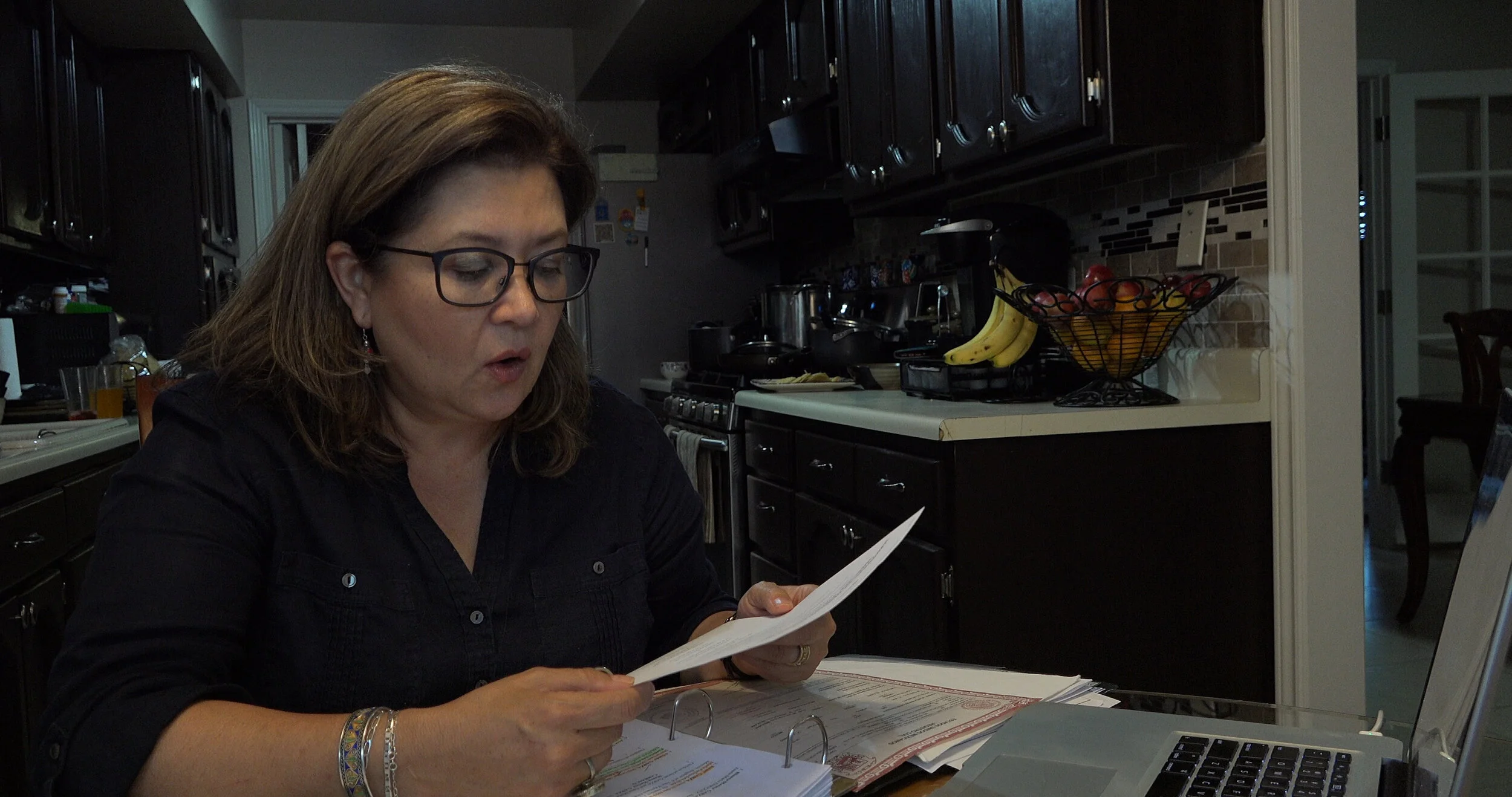 Blanca Carrasco looking through genealogy reports.