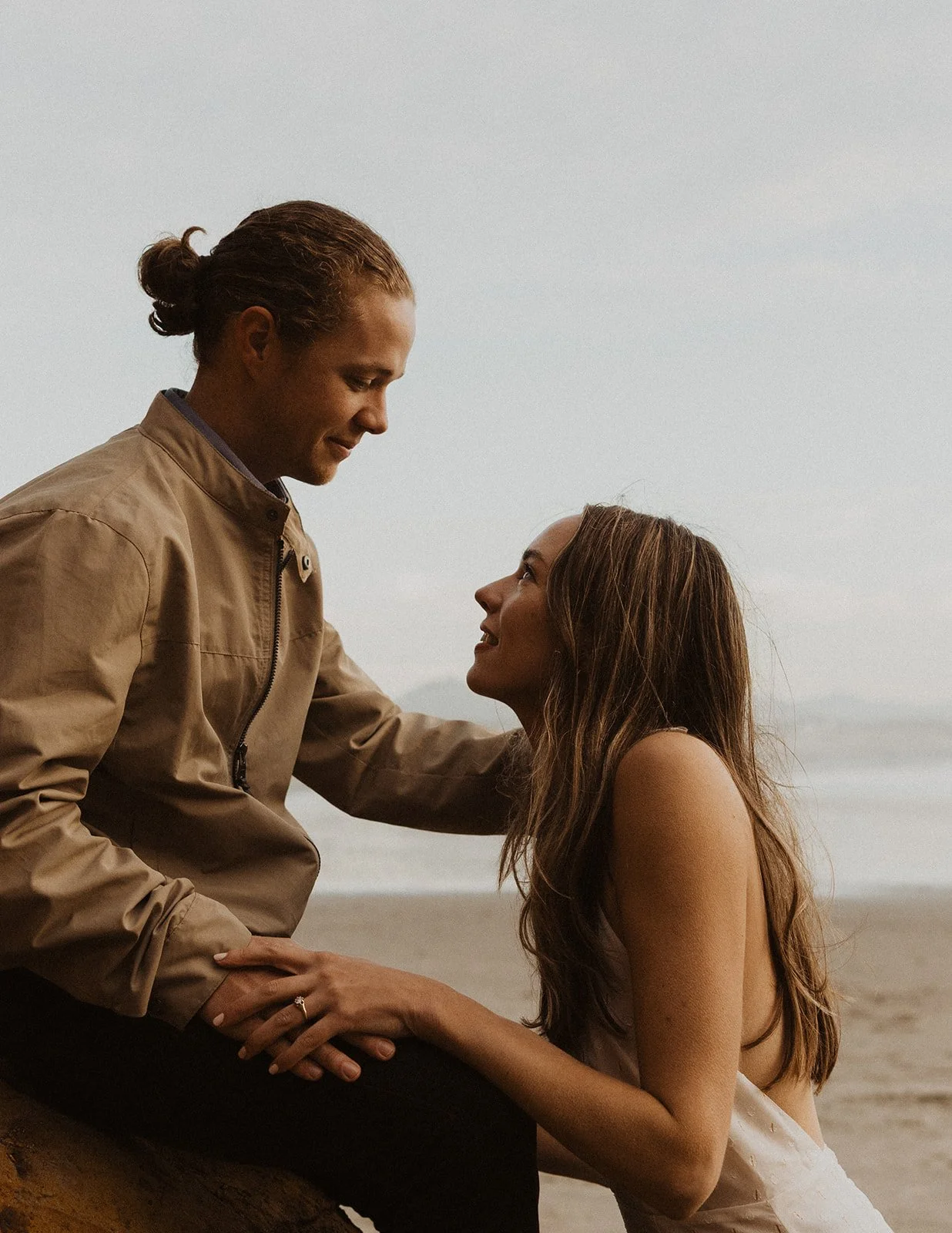 Romantic close-up of a couple by the ocean cliffs during an Oregon coast engagement session at golden hour