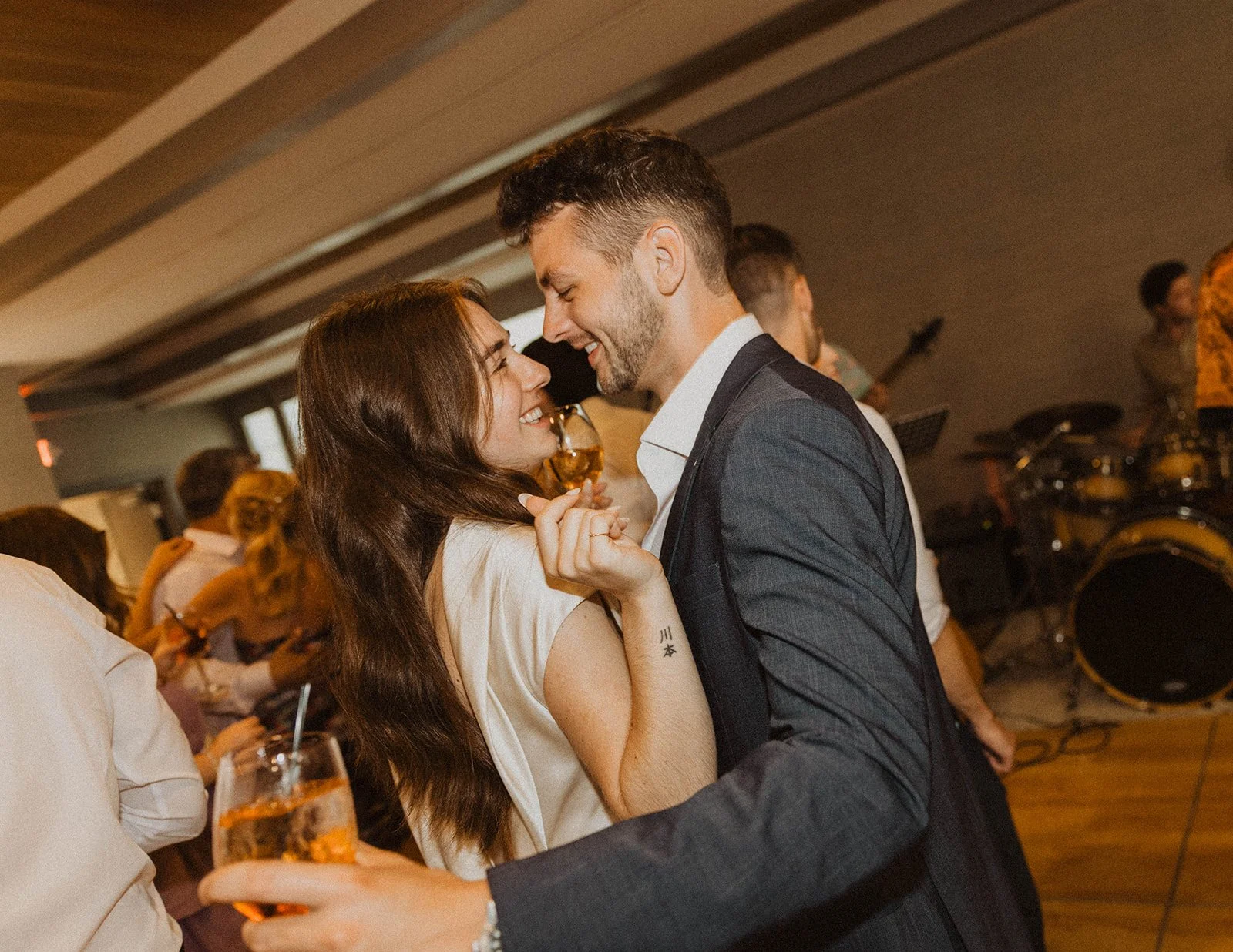 Newlywed couple smiling and dancing together during their intimate wedding reception celebration