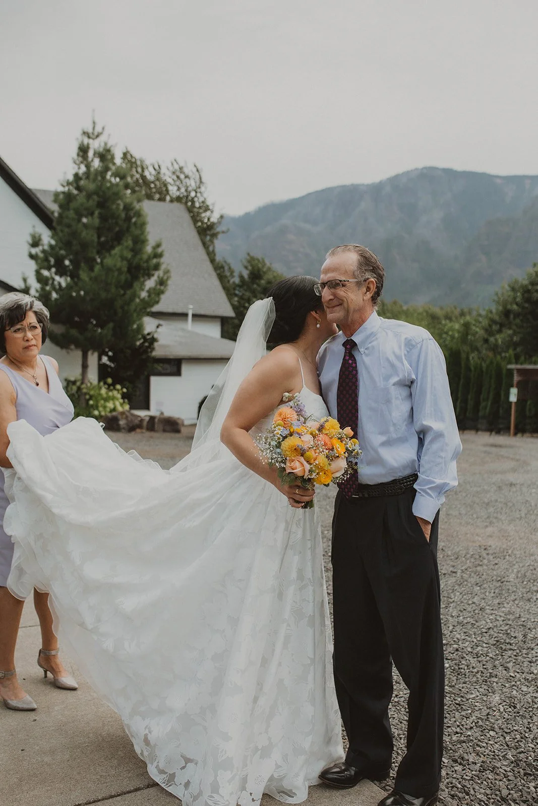 Emotional father-daughter first look in a lush garden as the bride and her father hold back tears before the wedding ceremony.