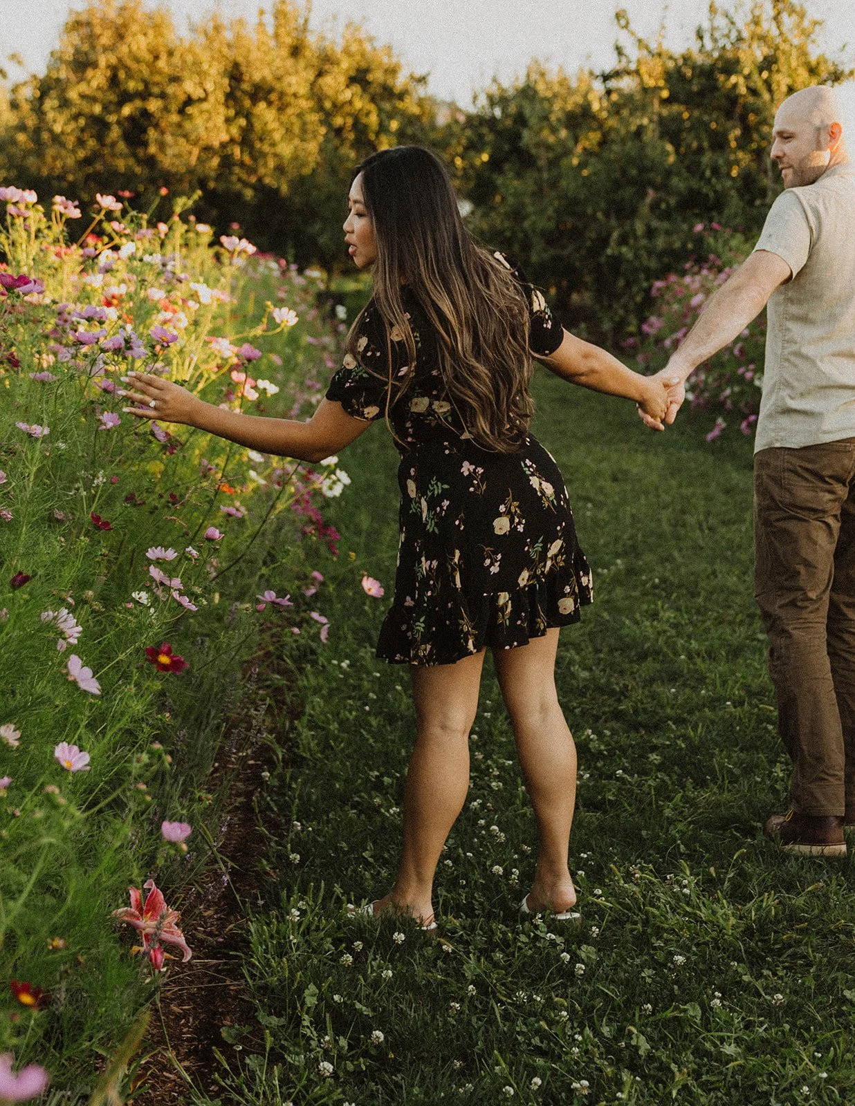 Engaged couple exploring a flower farm together during golden hour engagement photos in Oregon