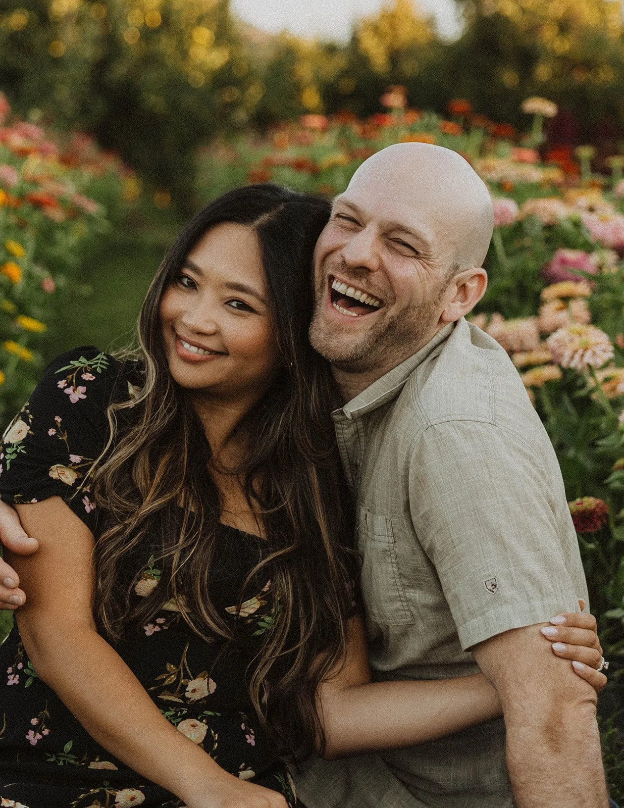 Couple smiling together in a flower field during golden hour engagement photos in Oregon
