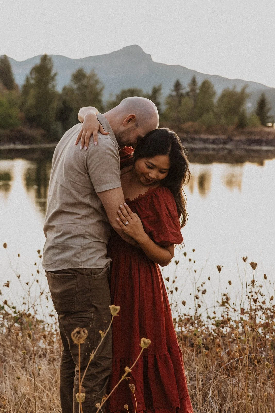 Couple embracing along the river during a relaxed Mt Hood engagement session with scenic mountain backdrops.