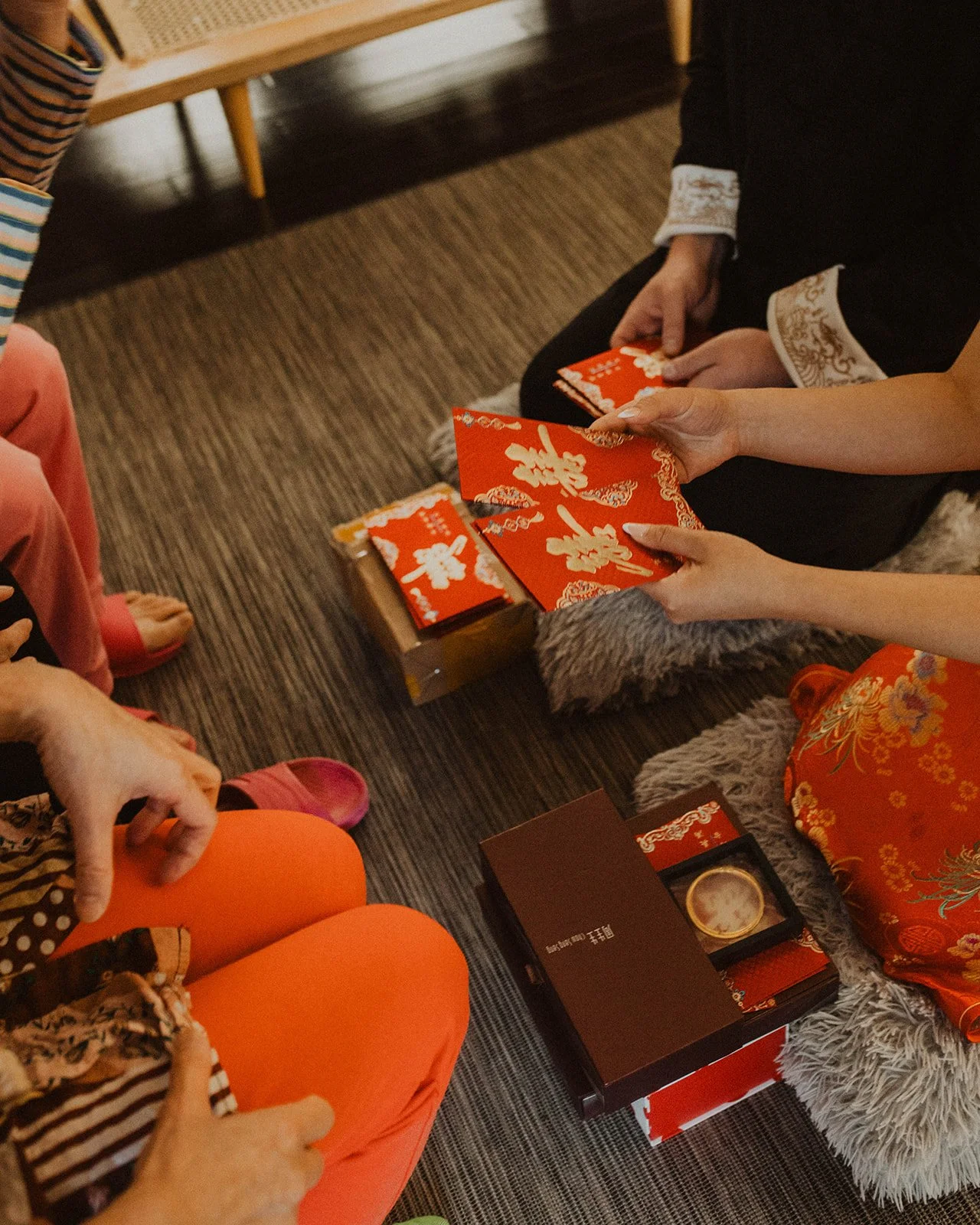 Bride distributes traditional red envelopes and gifts to family members during a Chinese wedding tea ceremony.