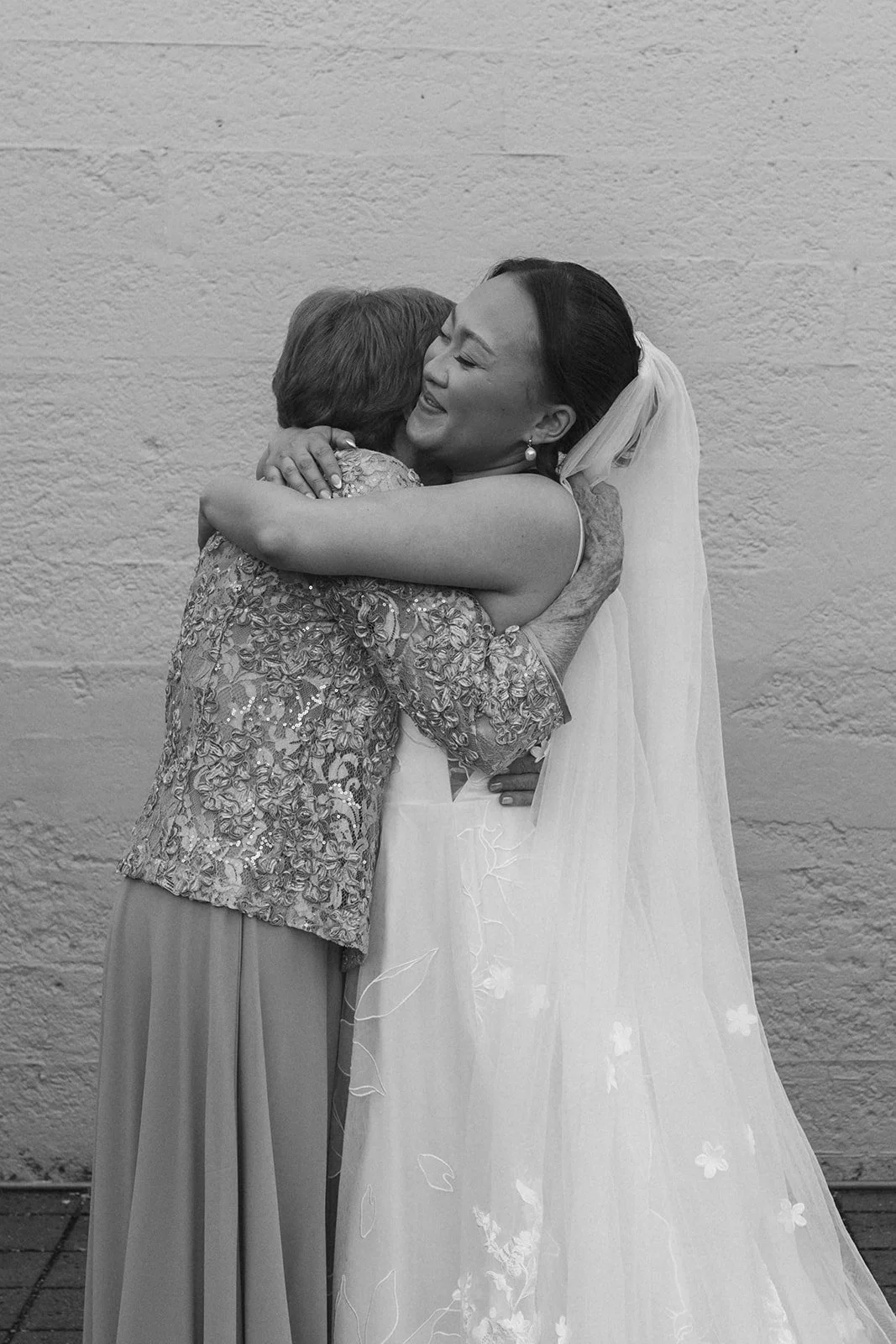 Bride embraces her grandmother during an emotional wedding day portrait, sharing a heartfelt hug after the ceremony.