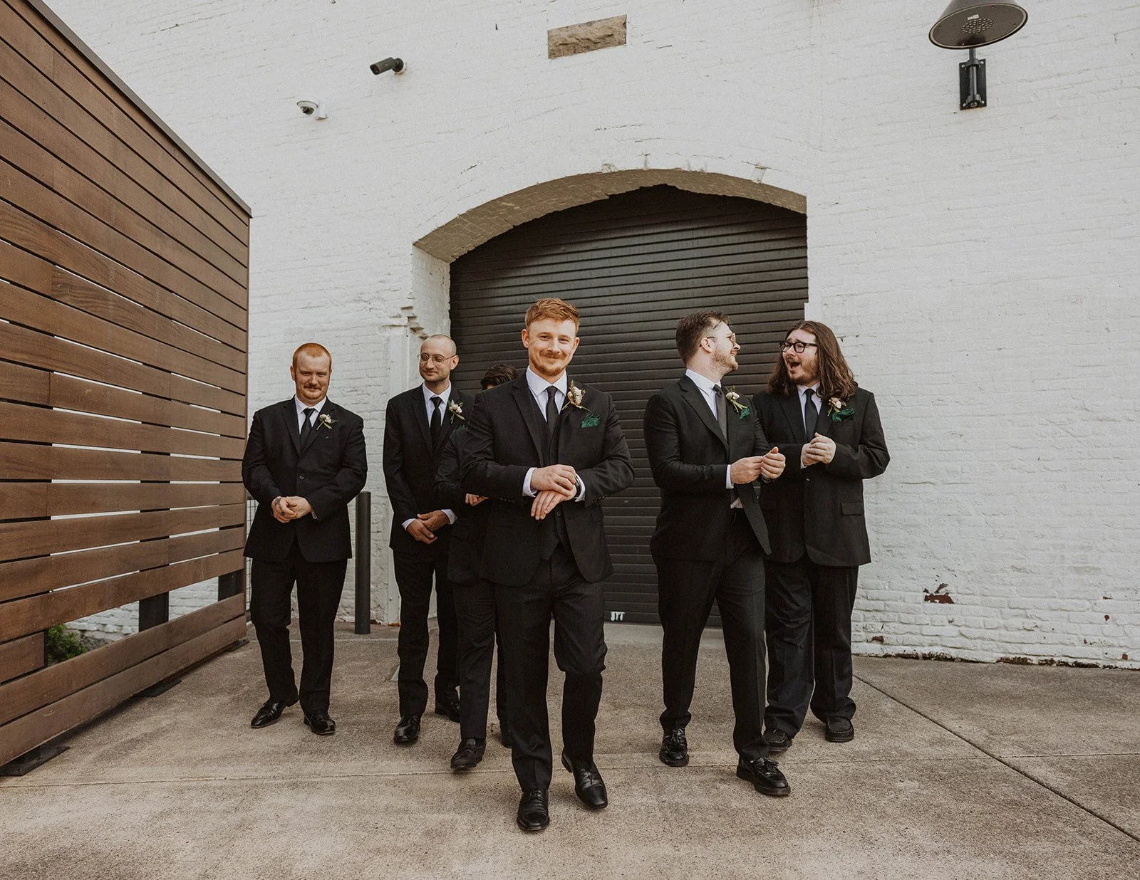 Groom and groomsmen walk together outside The Castaway wedding venue in Northwest Portland before the ceremony.