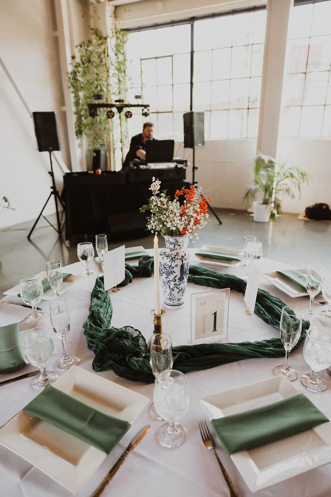 Wedding reception table with green linens, floral centerpiece, candles, and place settings at The Castaway in Portland.