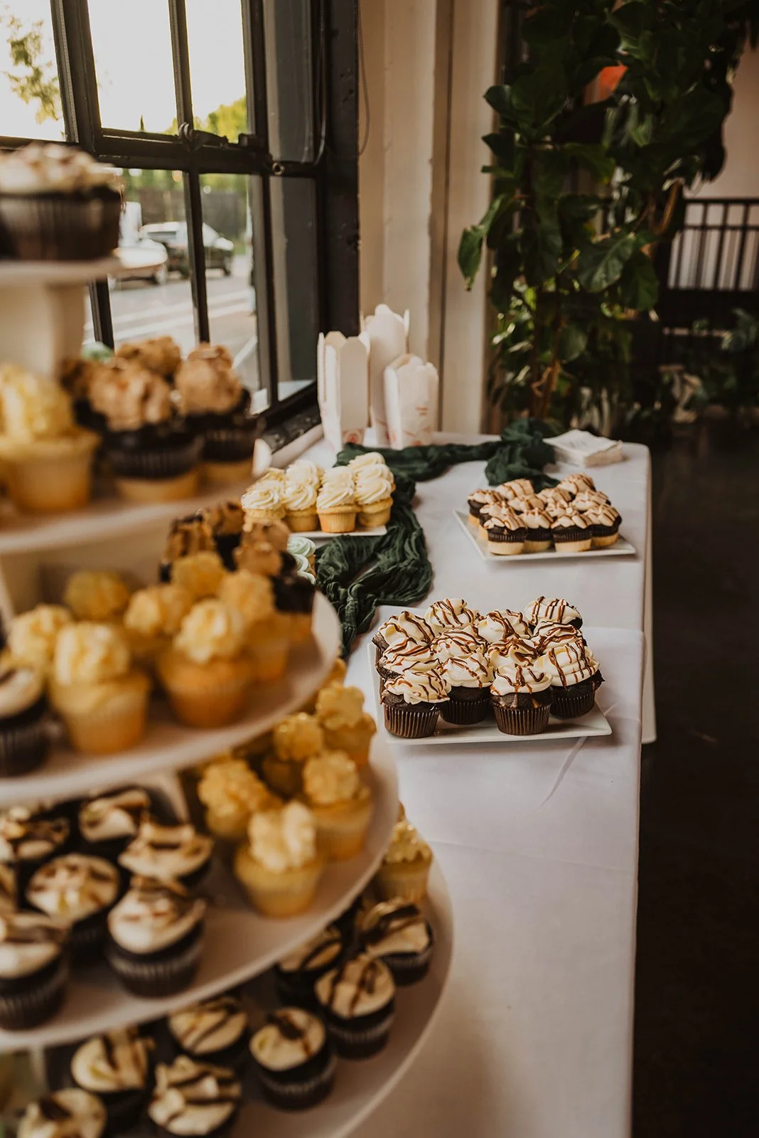 Assorted cupcakes and desserts displayed on a reception dessert table during a wedding at The Castaway in Portland.