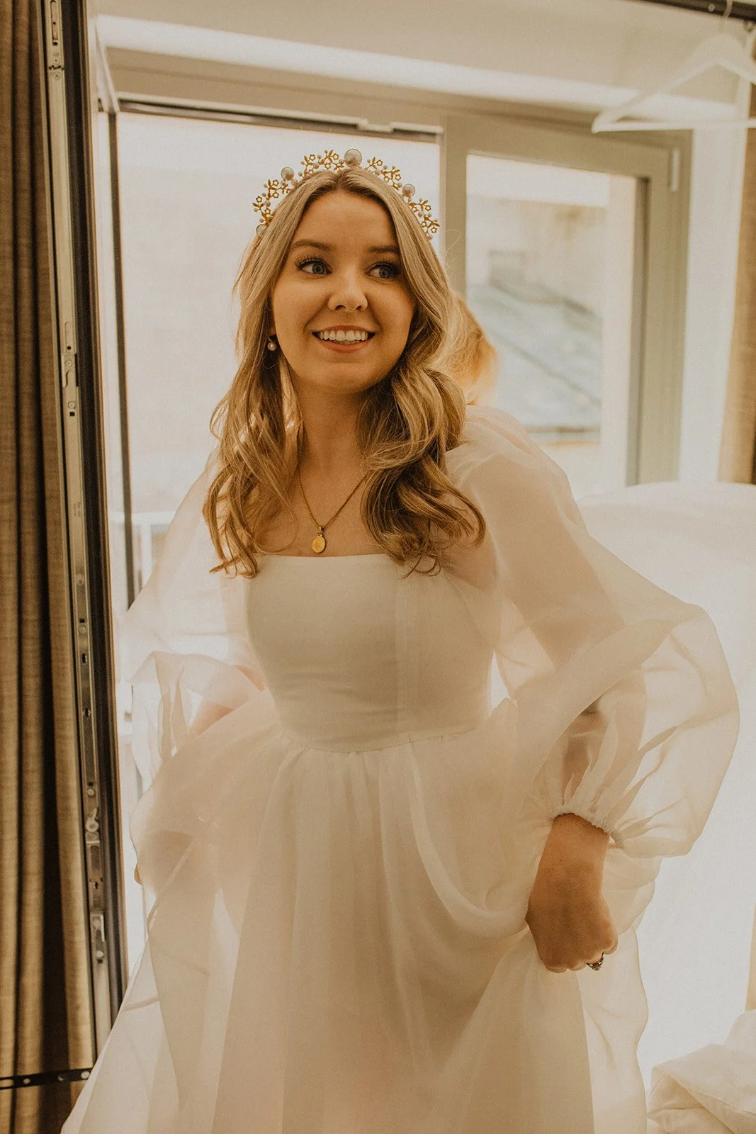 Bride smiling while getting ready for her Lake Como elopement, wearing a modern wedding dress and pearl headpiece before the ceremony at Villa del Balbianello.