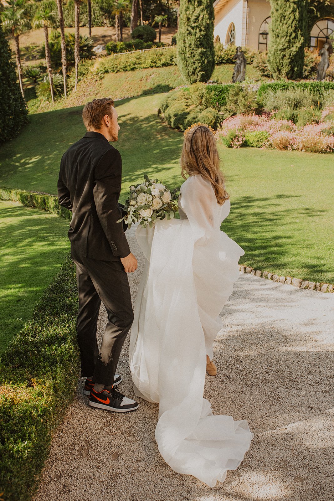 Newlyweds walking together through the gardens at Villa del Balbianello during their intimate Lake Como elopement portraits.