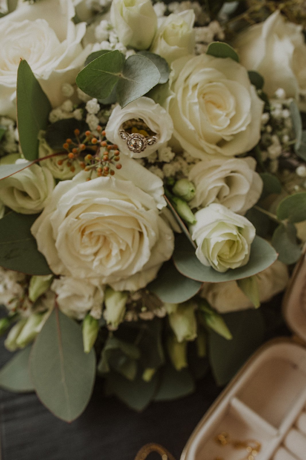 Engagement ring nestled inside a white rose bouquet with eucalyptus during a Lake Como wedding, highlighting floral details before the ceremony.