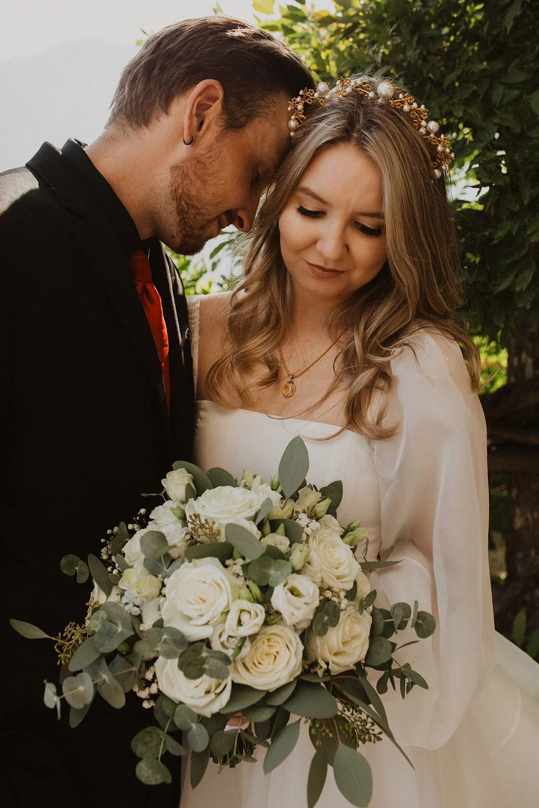 Romantic close-up portrait of a bride and groom embracing with a white rose bouquet during their Villa del Balbianello elopement.