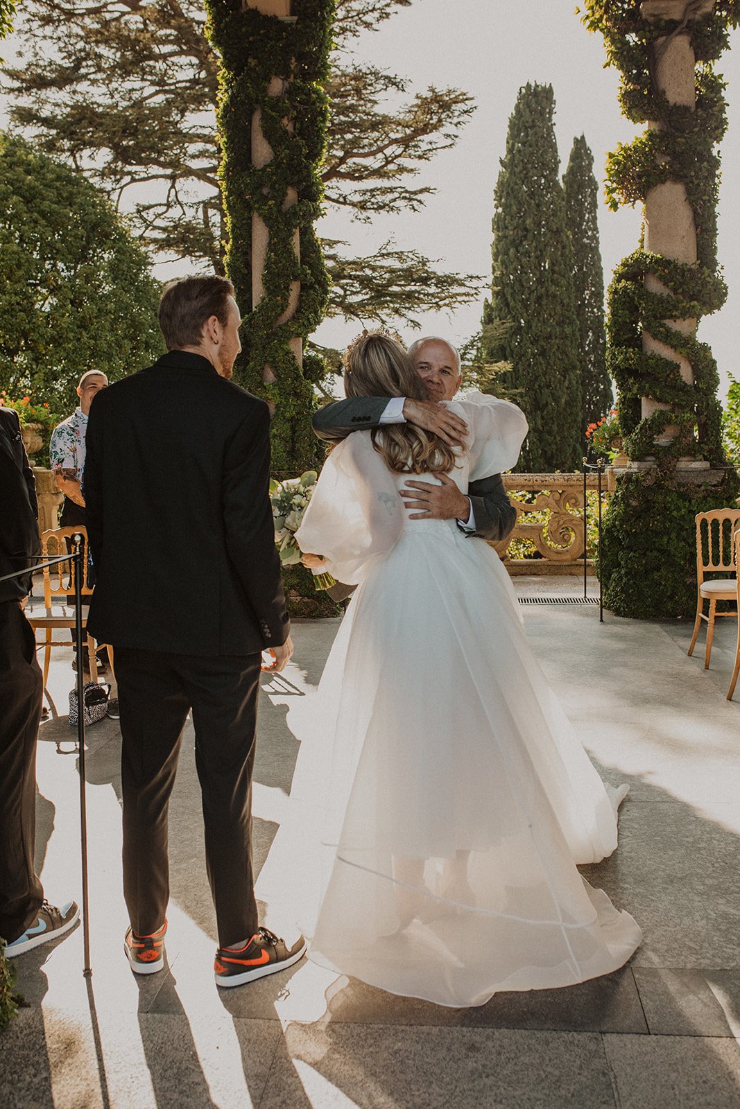 Bride shares an emotional hug with her father after he walks her down the aisle during their Lake Como wedding ceremony.