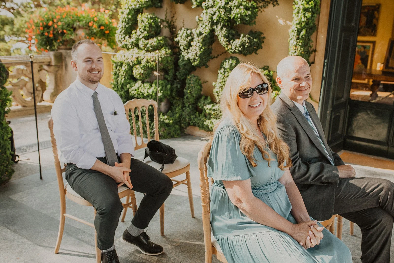 Wedding guests smiling as they watch the couple exchange vows during an intimate Lake Como wedding ceremony.