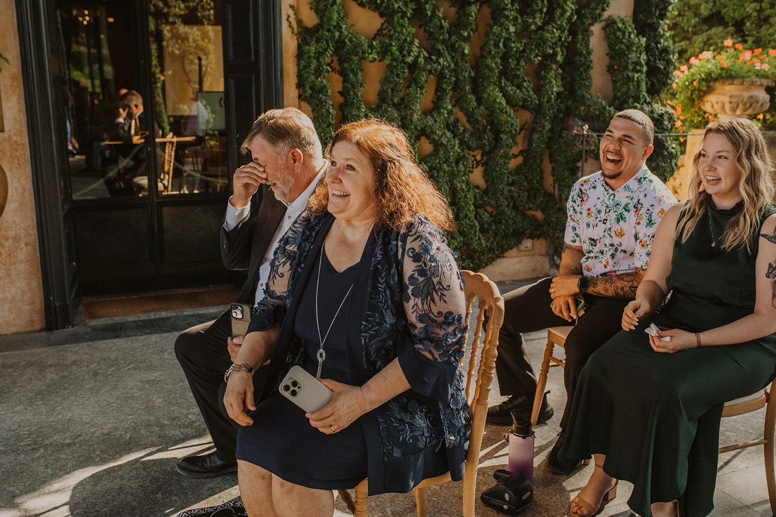 Family members and wedding guests laughing during an intimate outdoor ceremony at Villa del Balbianello on Lake Como.