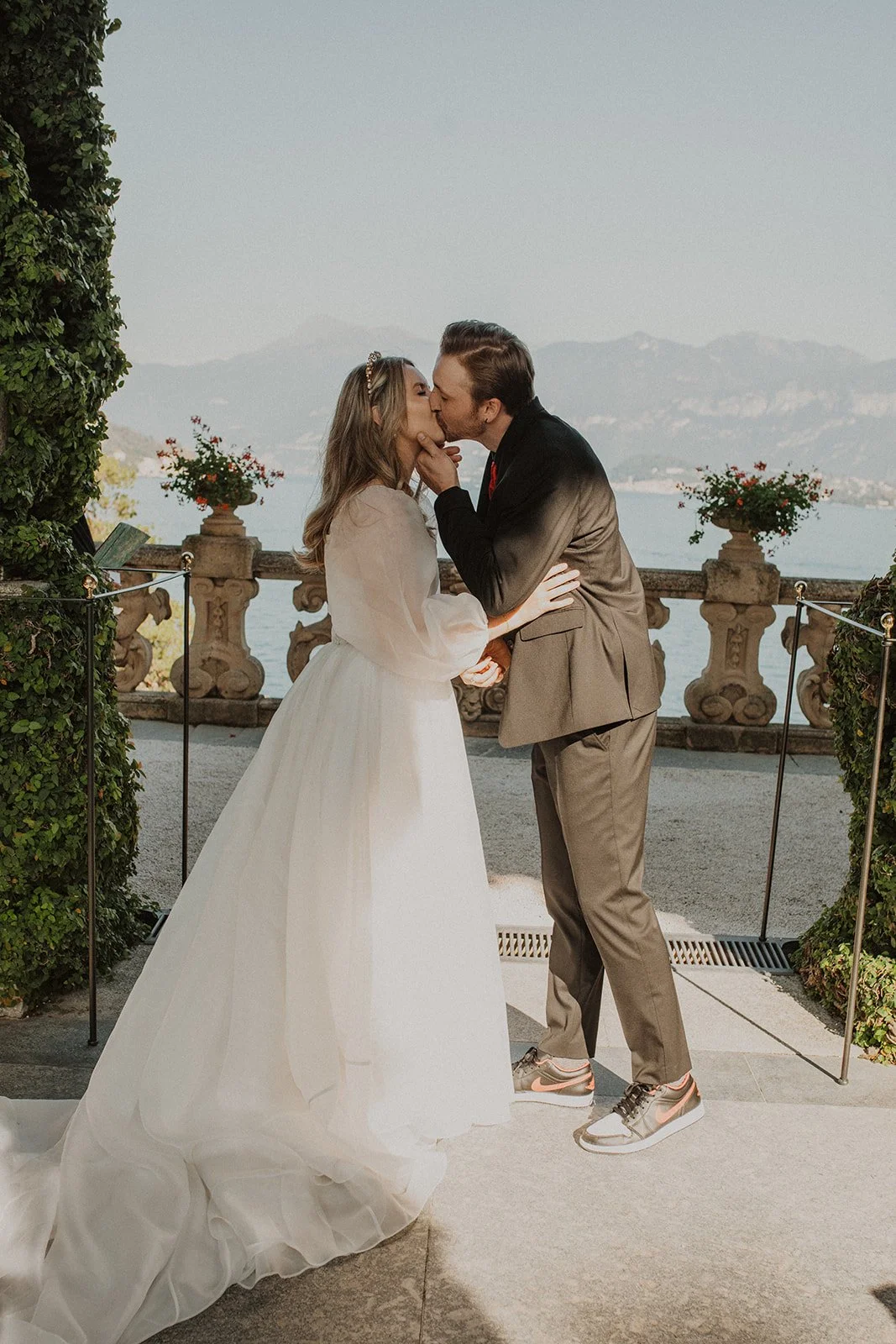 Bride and groom sharing their first kiss after exchanging vows during their intimate Lake Como elopement at Villa del Balbianello.
