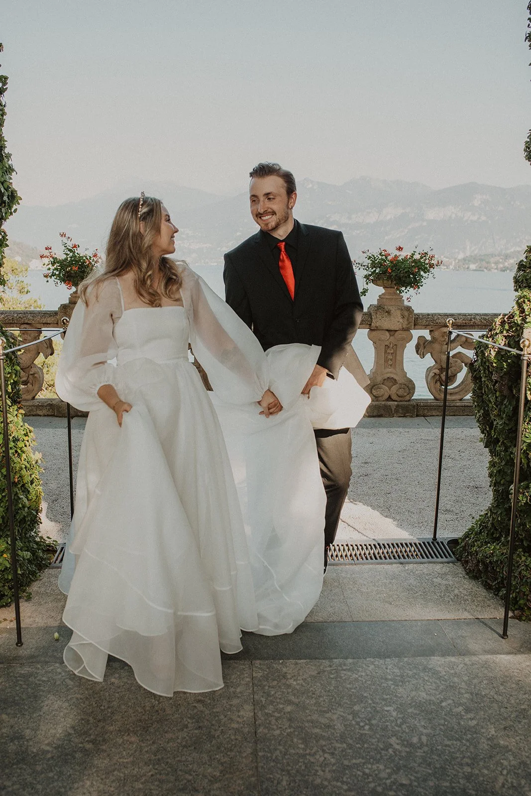 Newly married couple walking hand in hand through the gardens of Villa del Balbianello after their intimate Lake Como elopement ceremony.