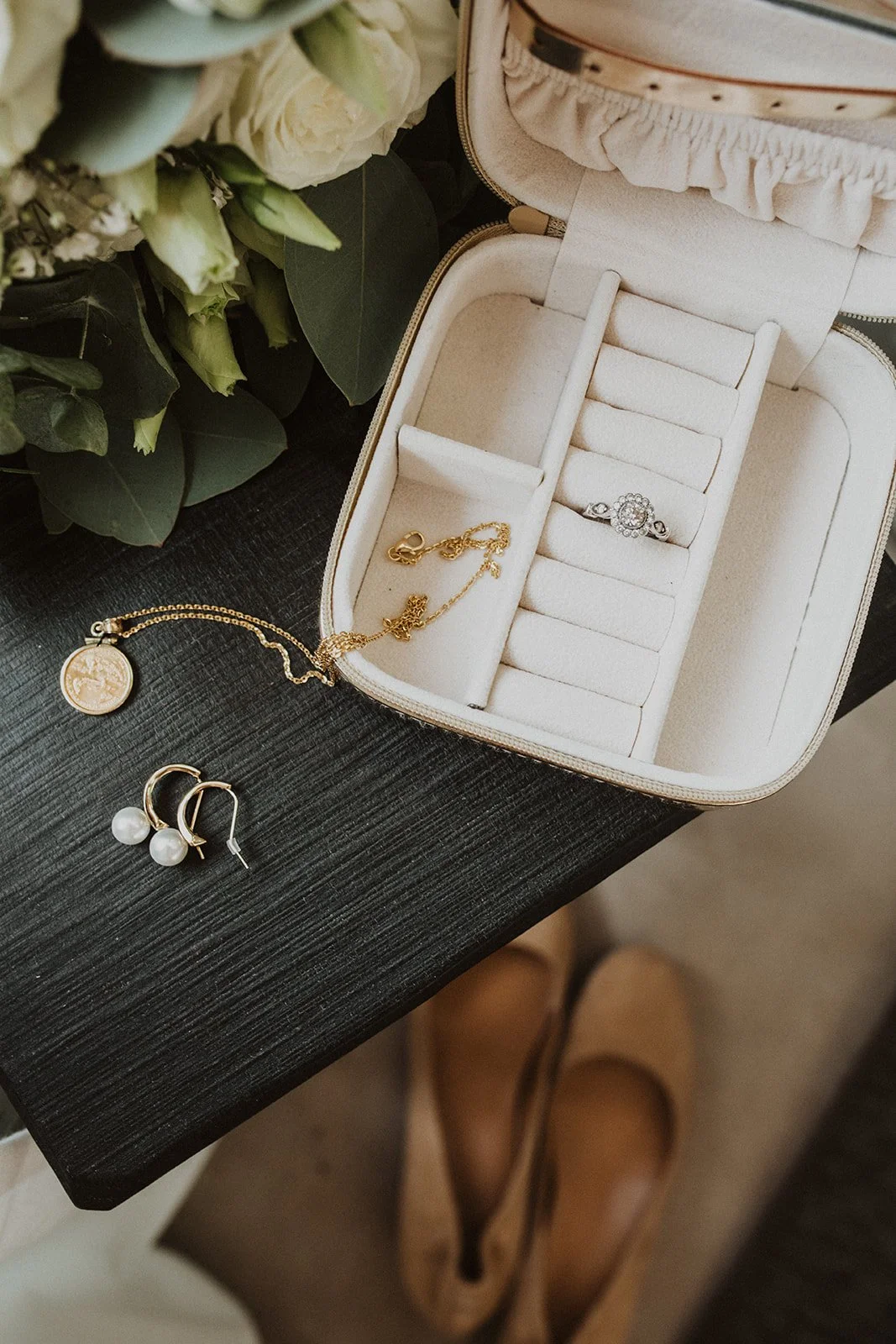 Bride's wedding details featuring an engagement ring, pearl earrings, gold necklace, and bouquet styled for a Lake Como elopement.