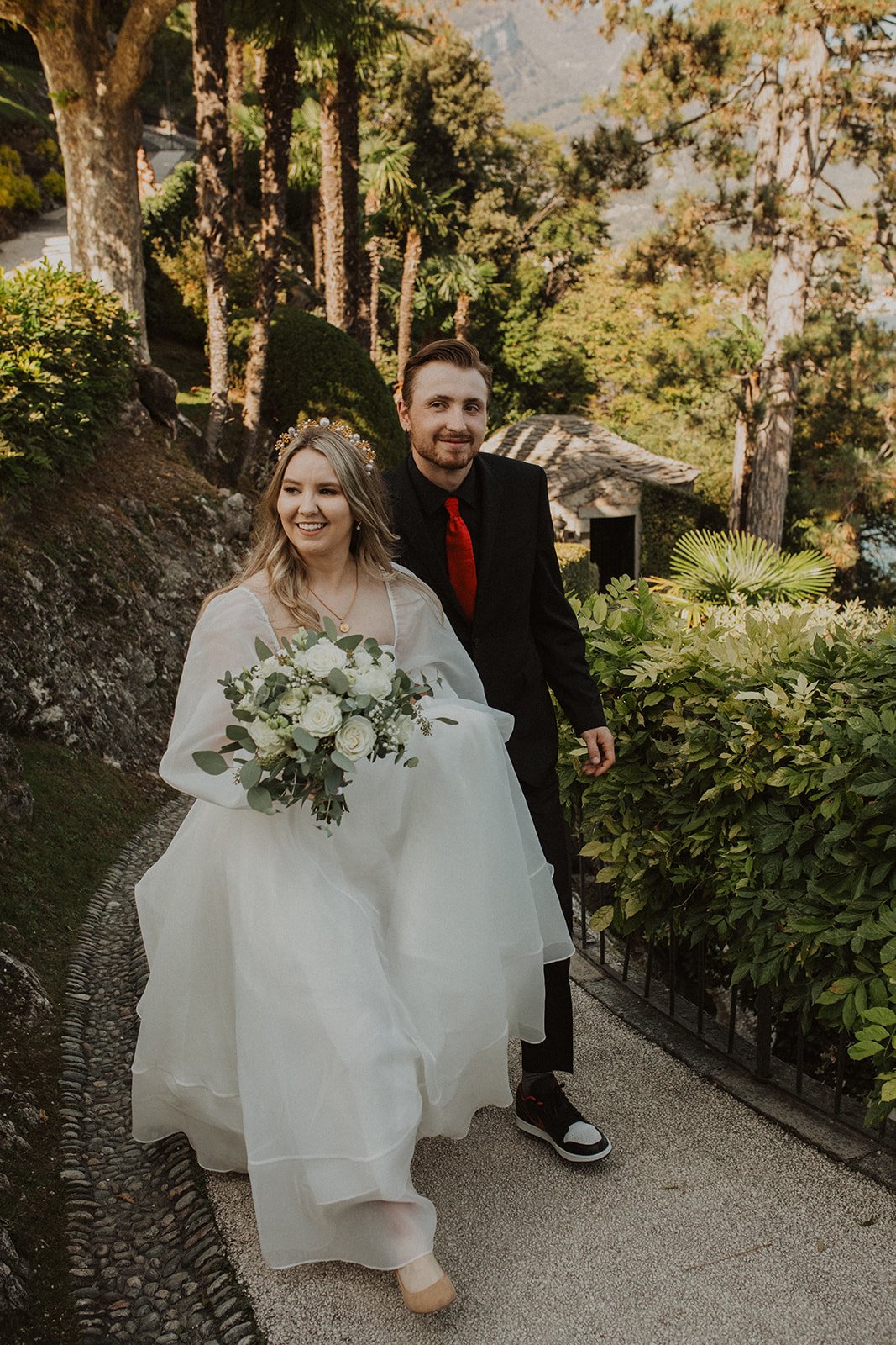 Bride and groom walking through the lush gardens of Villa del Balbianello during their Lake Como elopement portrait session.