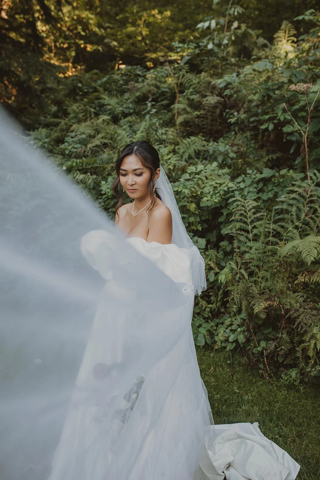 Bride standing quietly among lush greenery during bridal portraits at a Bridal Veil Lakes wedding in the Columbia River Gorge.
