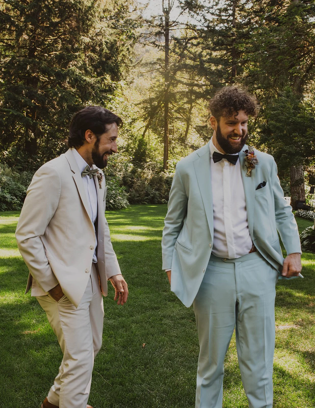 Groom and groomsman laughing together during candid portraits on the lawn at Bridal Veil Lakes in Oregon.