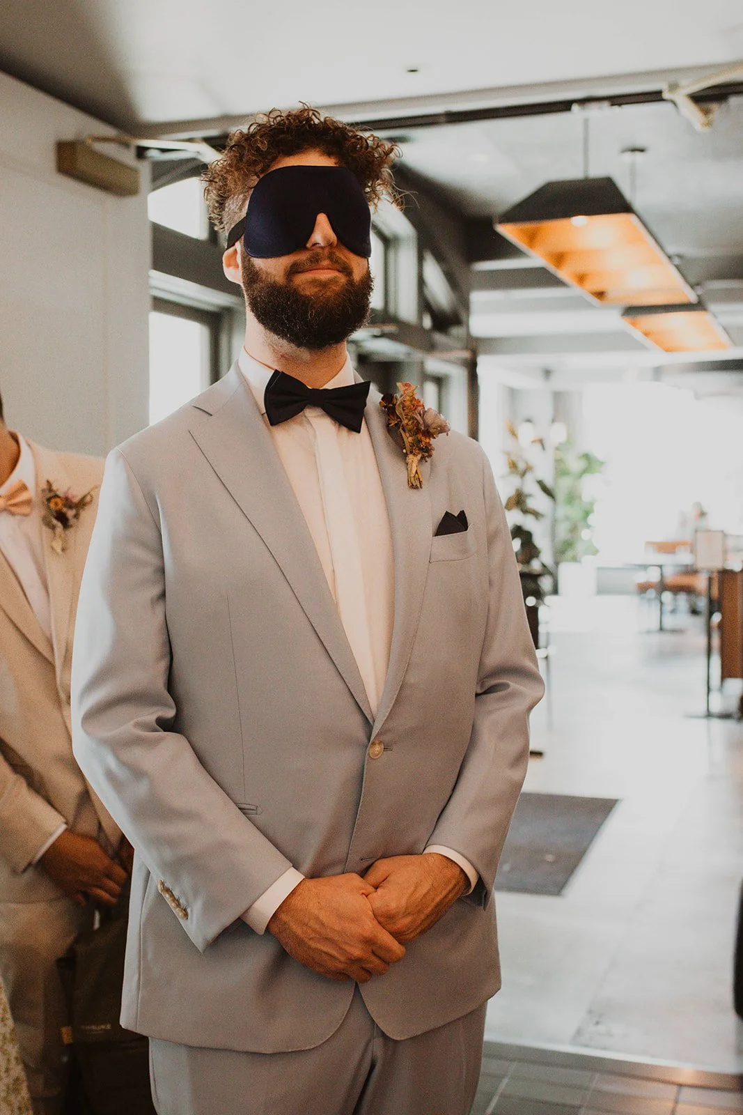 Groom standing blindfolded in a light blue suit before a surprise first look with his bride at Bridal Veil Lakes in Oregon.