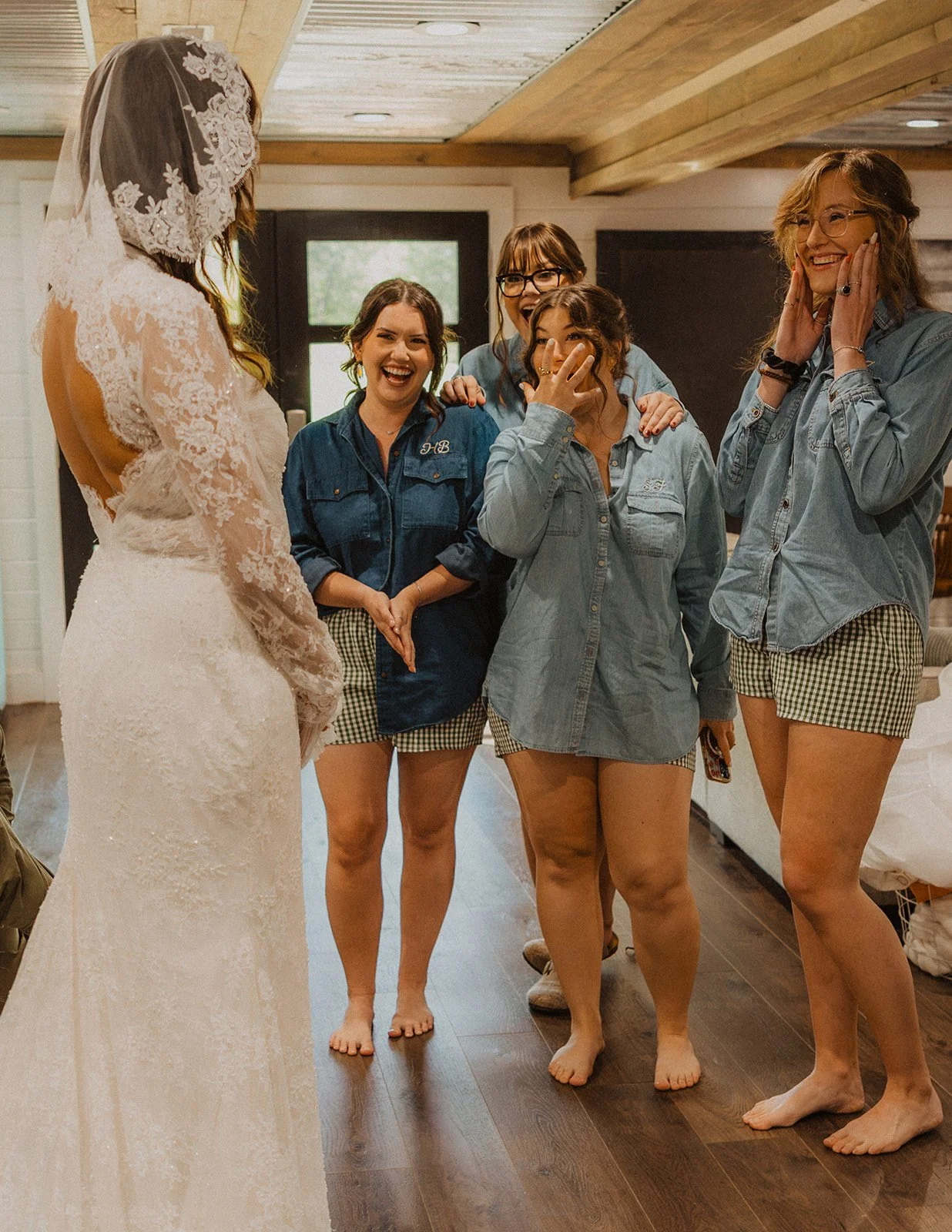 Bridesmaids reacting with excitement during a first look as the bride reveals her lace wedding dress at Bright Morning Farm.