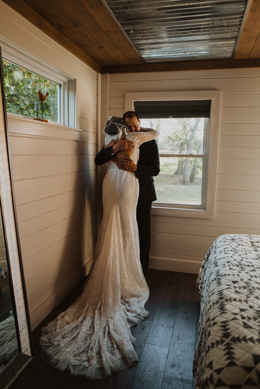 Bride and her father sharing a quiet hug inside the getting-ready suite before the wedding ceremony at Bright Morning Farm.