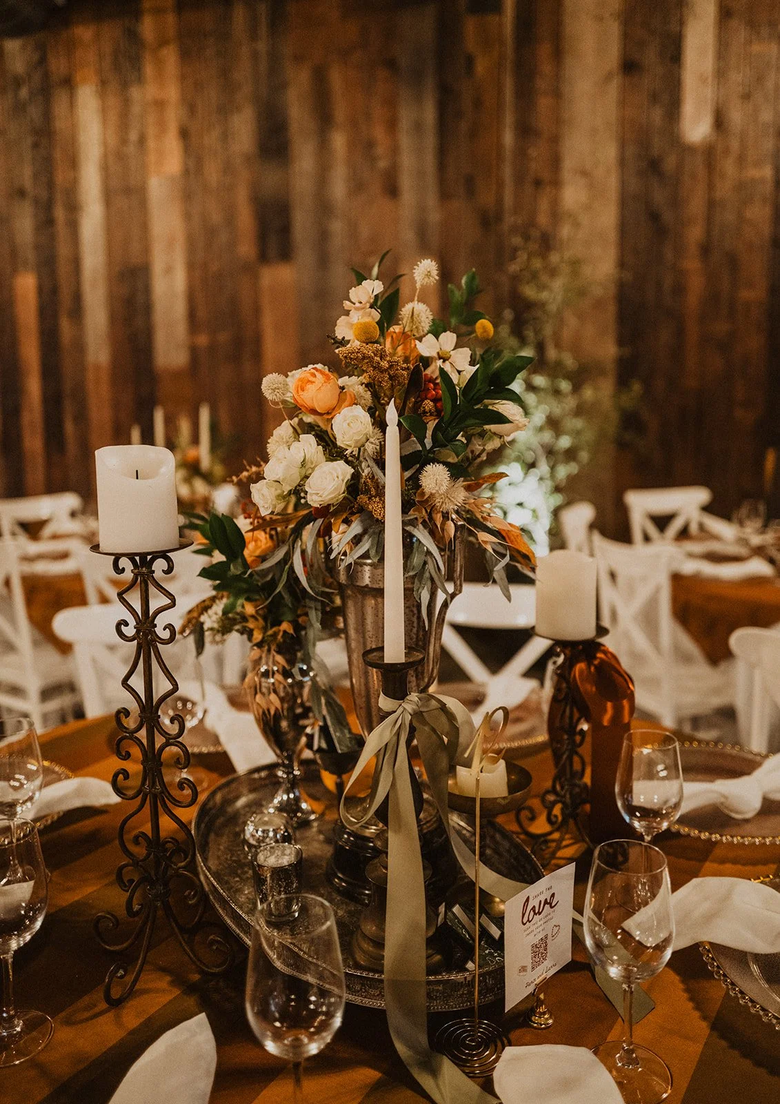 Wedding reception centerpiece with seasonal florals, vintage candleholders, and elegant table settings inside Bright Morning Farm.