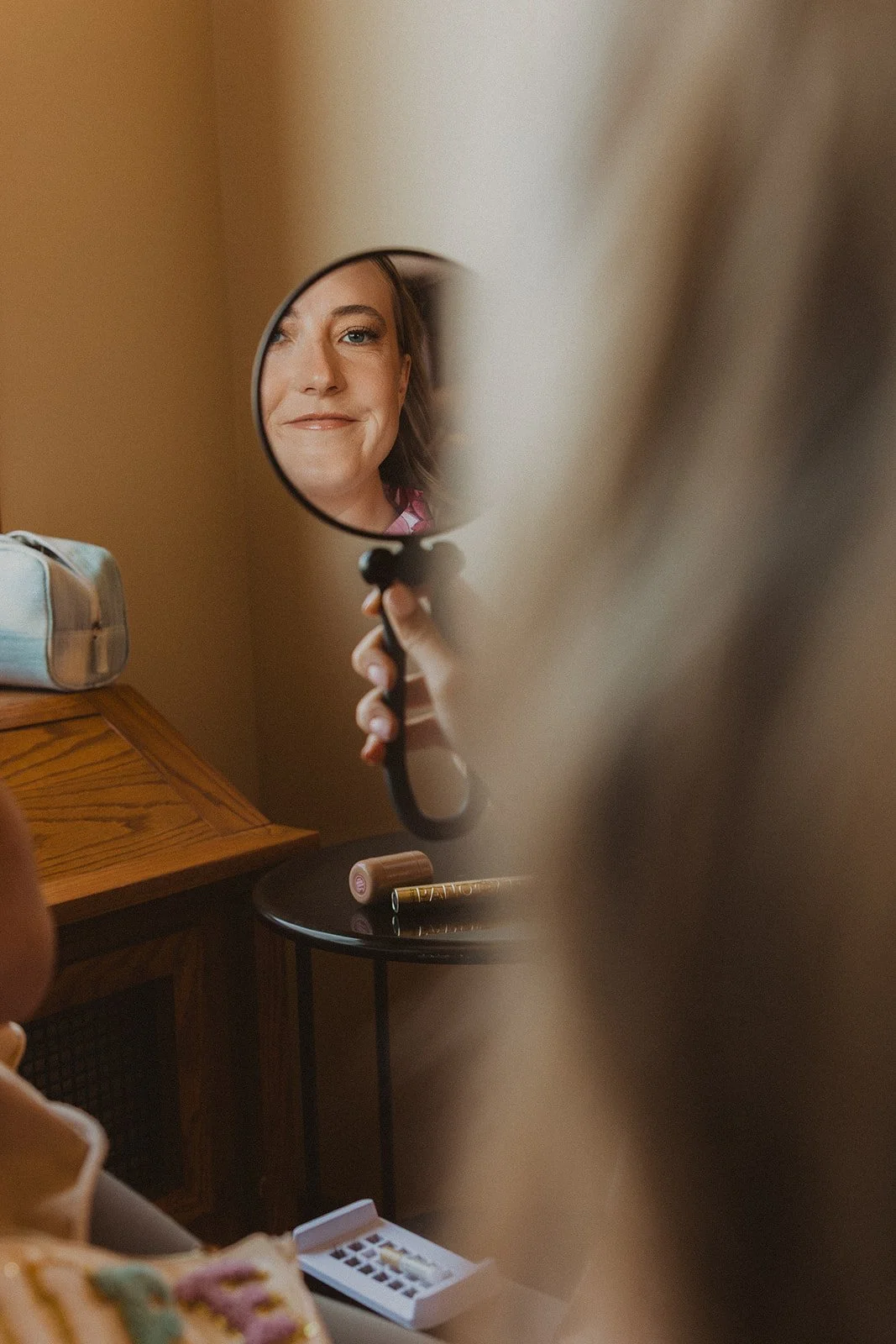 Bride checking her makeup in a handheld mirror while getting ready before her wedding at Skamania Lodge.