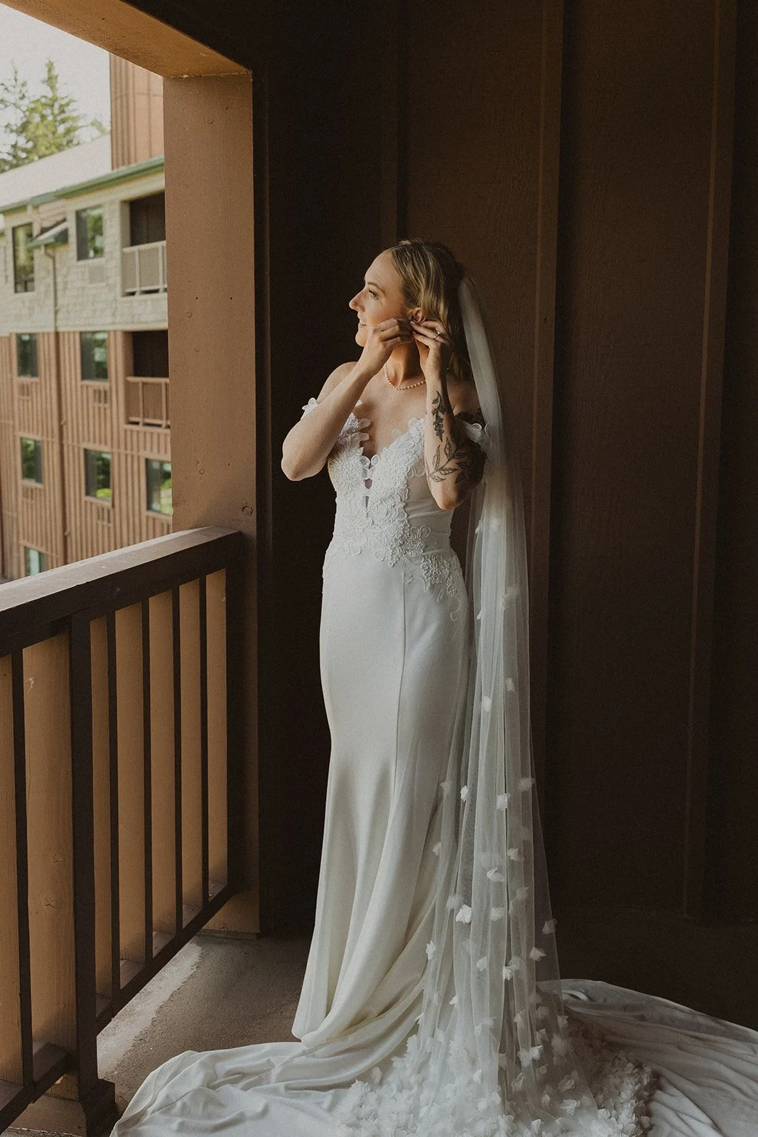 Bride putting on her earrings on the balcony outside her room before her Skamania Lodge wedding ceremony.