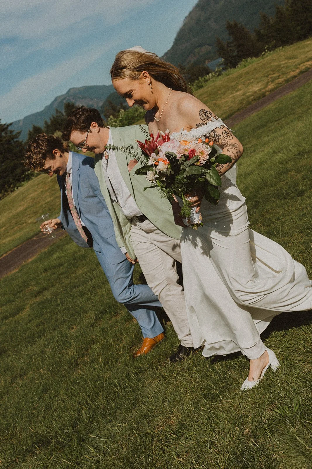 Bride laughing with members of her wedding party while walking across the lawn at Skamania Lodge.