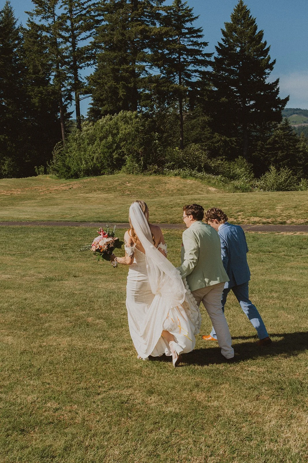 Bride walking across the lawn with family members before her outdoor wedding ceremony at Skamania Lodge.