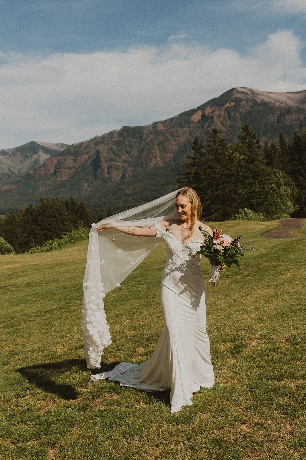 Bride holding her veil during bridal portraits with mountain views at Skamania Lodge.