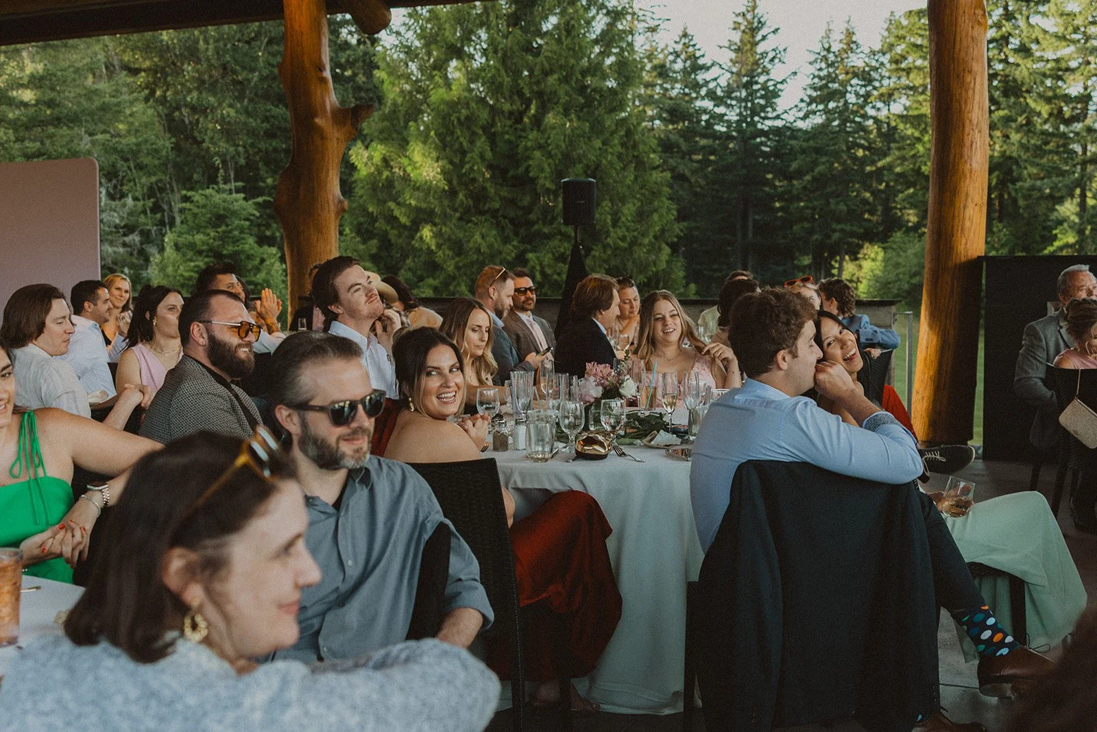 speeches.jpg Wedding guests smiling and listening during reception speeches at Skamania Lodge.