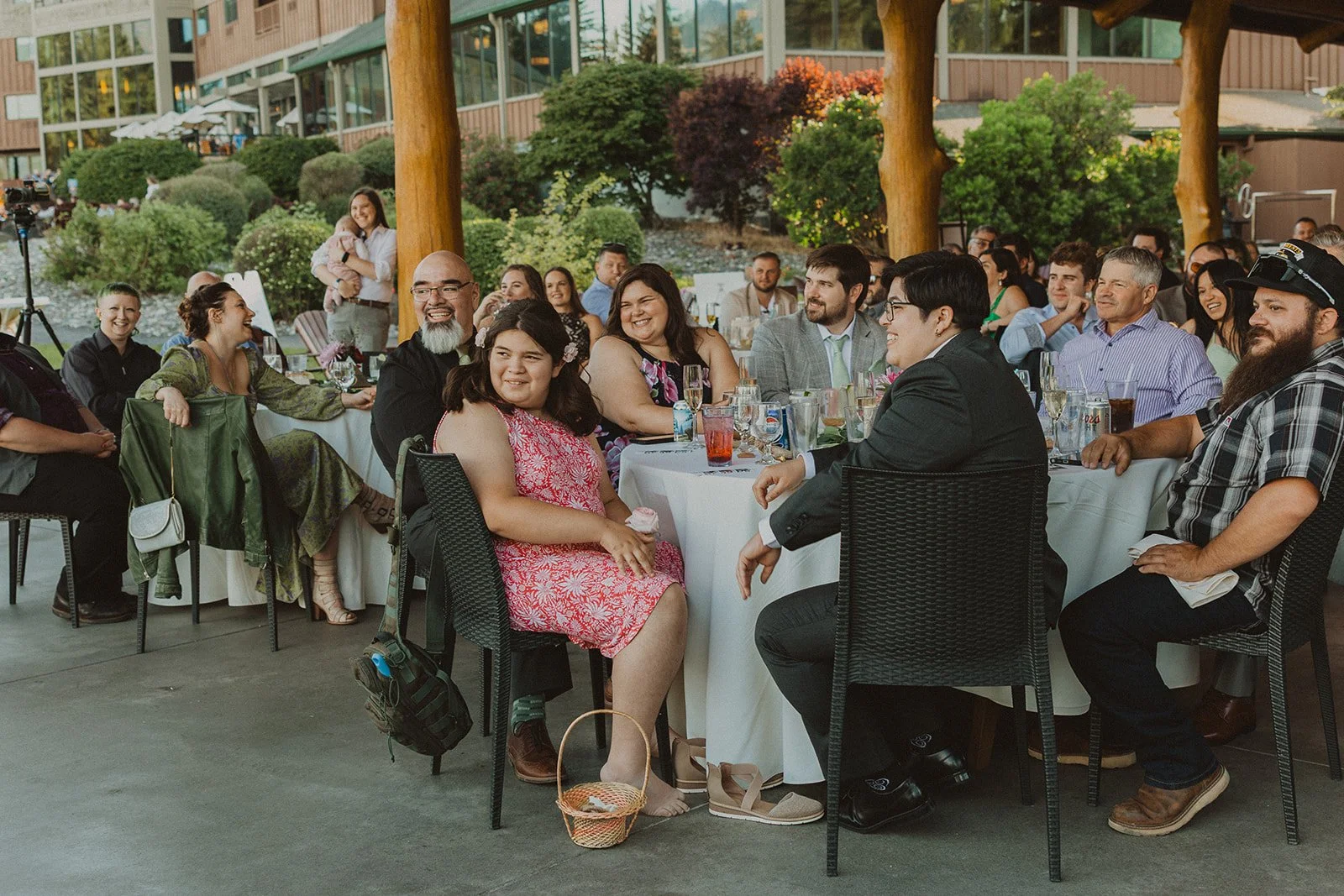 Wedding guests laughing during speeches at an outdoor covered reception at Skamania Lodge.
