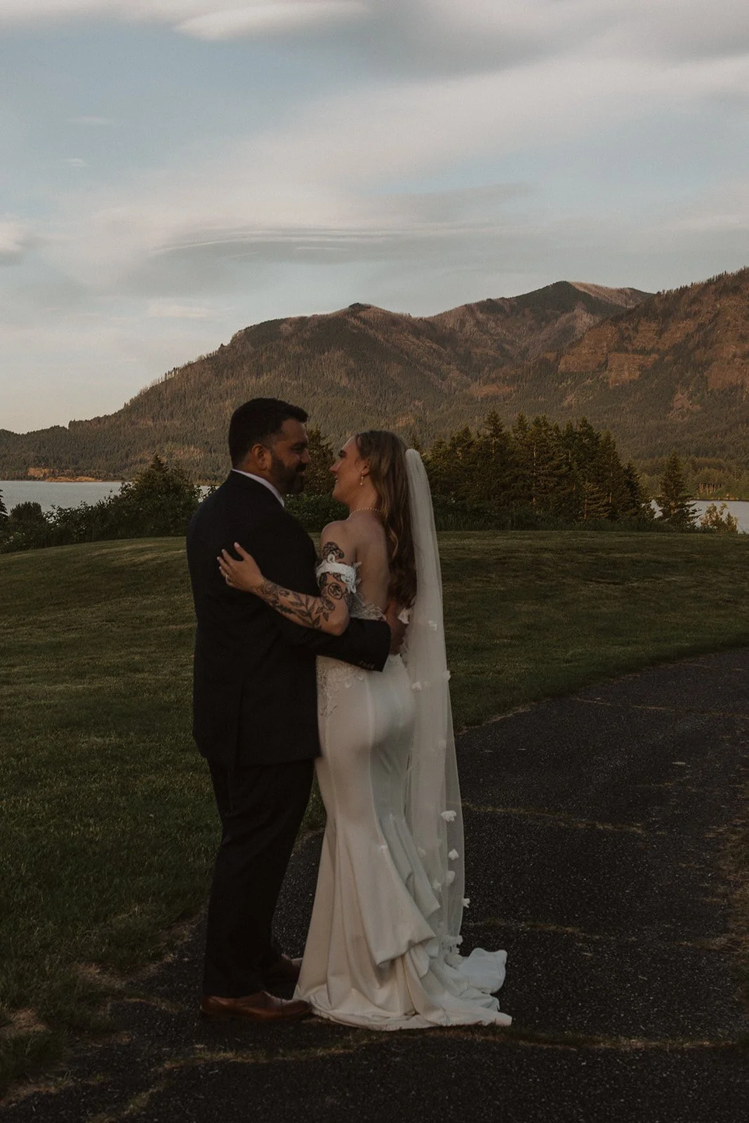 Newlyweds embracing during sunset portraits with mountain views at Skamania Lodge.